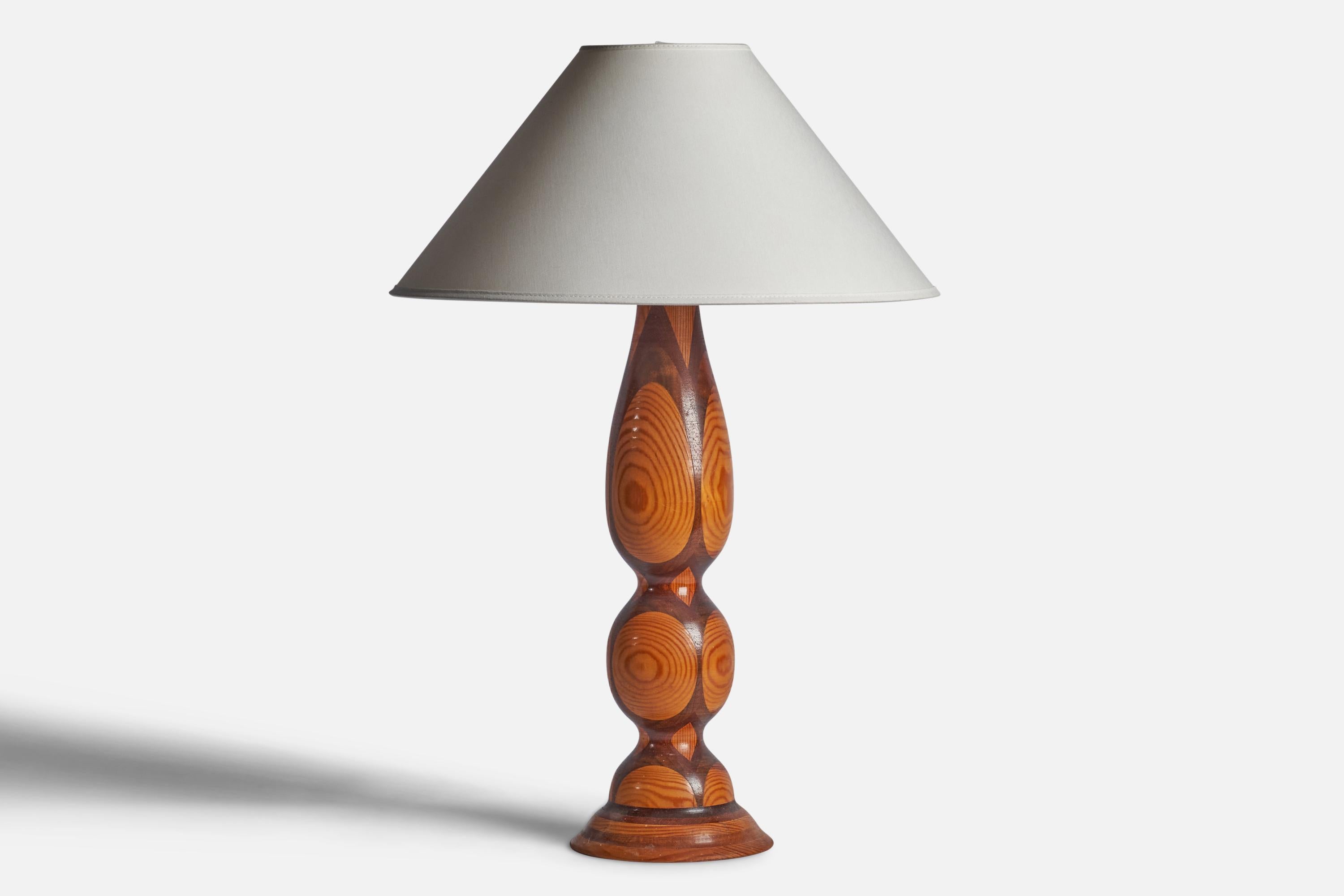 A stack-laminated and turned walnut and pine table lamp designed and produced in the US, 1950s.

Dimensions of Lamp (inches): 19.55” H x 5.85” Diameter
Dimensions of Shade (inches): 4.5” Top Diameter x 16” Bottom Diameter x 7.15” H 
Dimensions of