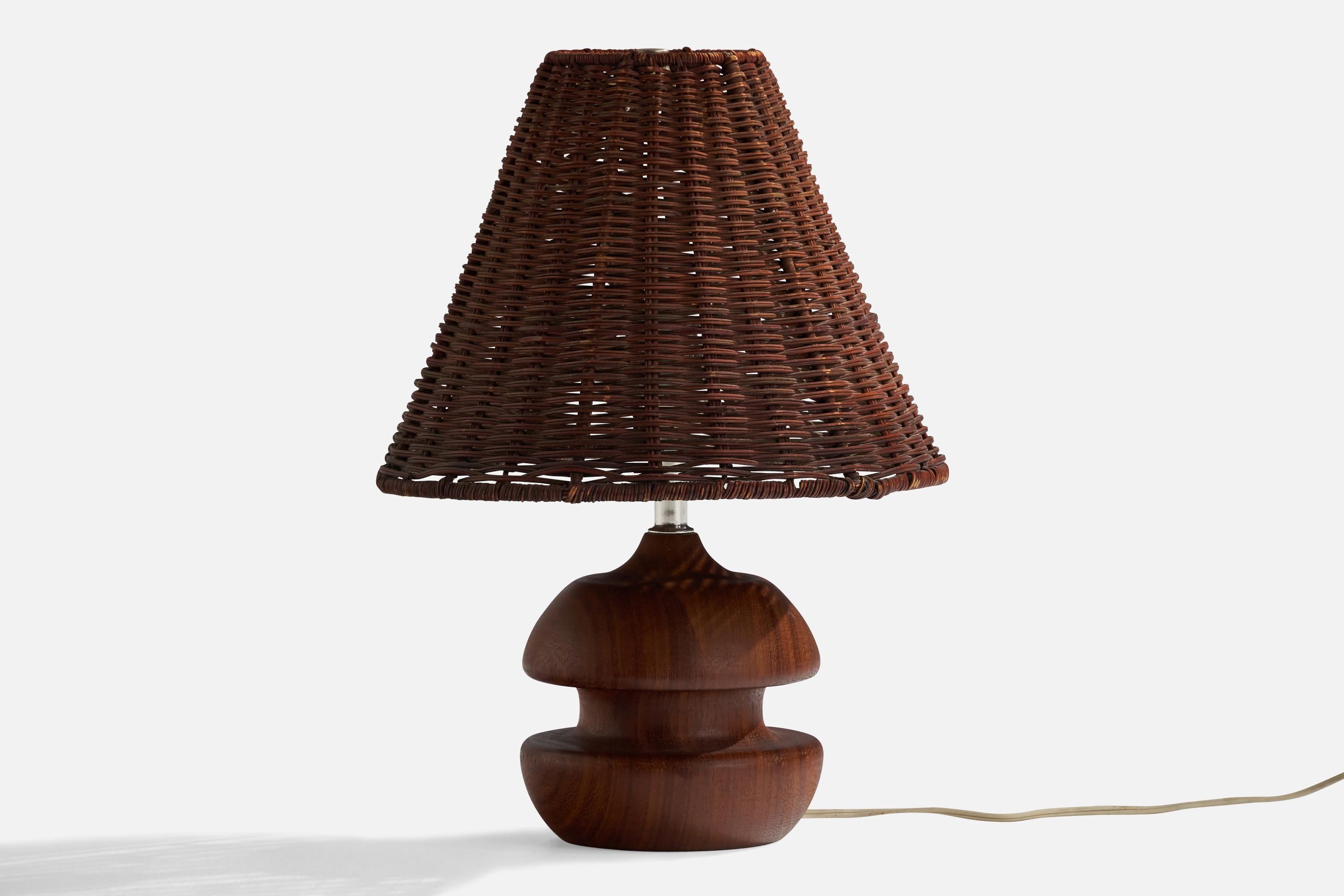 A teak, brass and rattan table lamp designed and produced in the US, 1960s.

Overall Dimensions (inches): 15.25” H x 11.25” Diameter
Stated dimensions include shade.
Bulb Specifications: E-26 Bulb
Number of Sockets: 1
All lighting will be converted