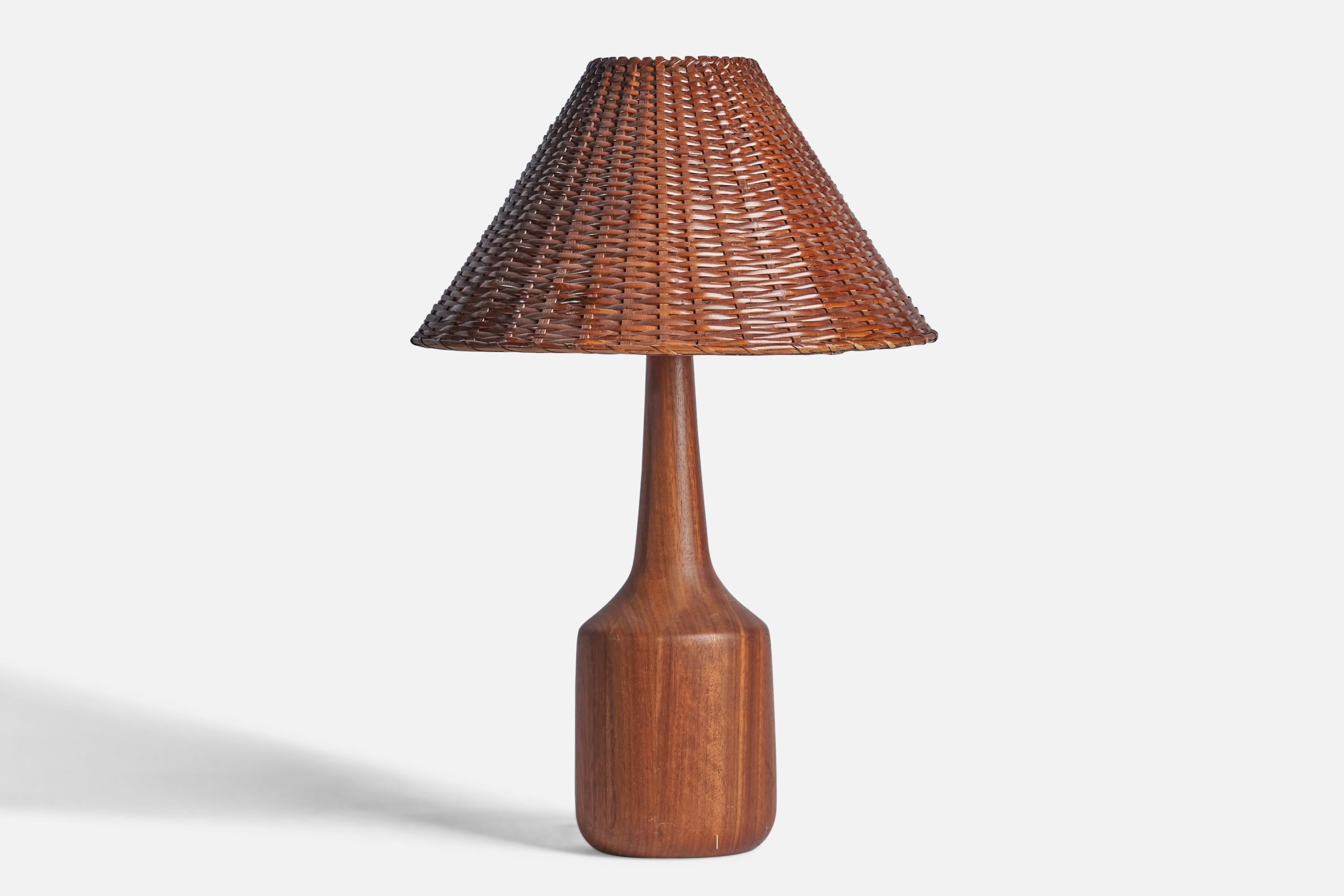 A teak and rattan table lamp designed and produced in the US, 1950s.

Overall Dimensions (inches): 28.5” H x 19” Diameter
Bulb Specifications: E-26 Bulb
Number of Sockets: 1
All lighting will be converted for US usage. We are unable to confirm that