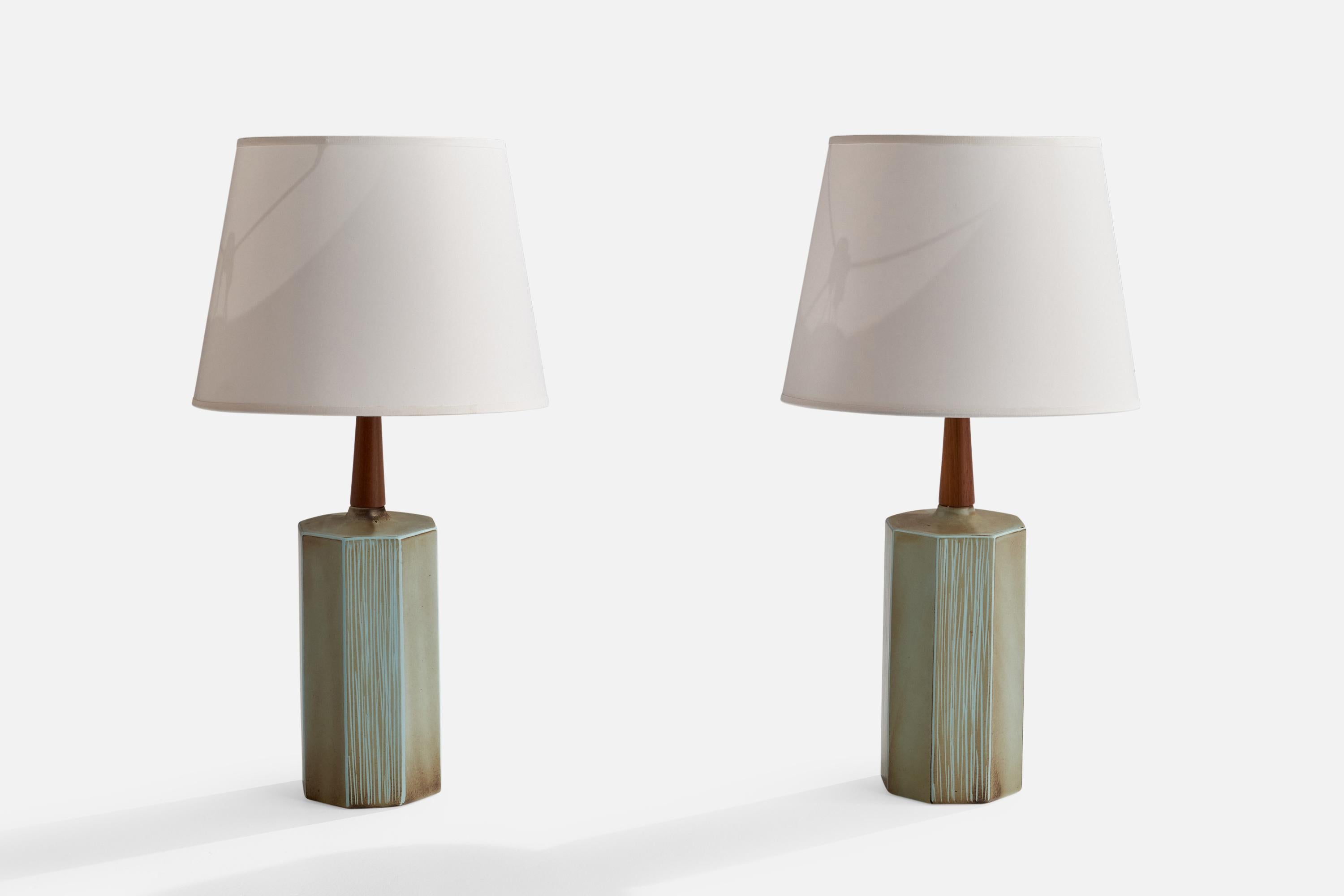 A pair of ceramic and walnut table lamp designed and produced in the US, 1950s.

Overall Dimensions (inches): 22.5”  H x 11.5” W x 4.75” D
Stated dimensions include shade.
Bulb Specifications: E-26 Bulb
Number of Sockets: 2
All lighting will be