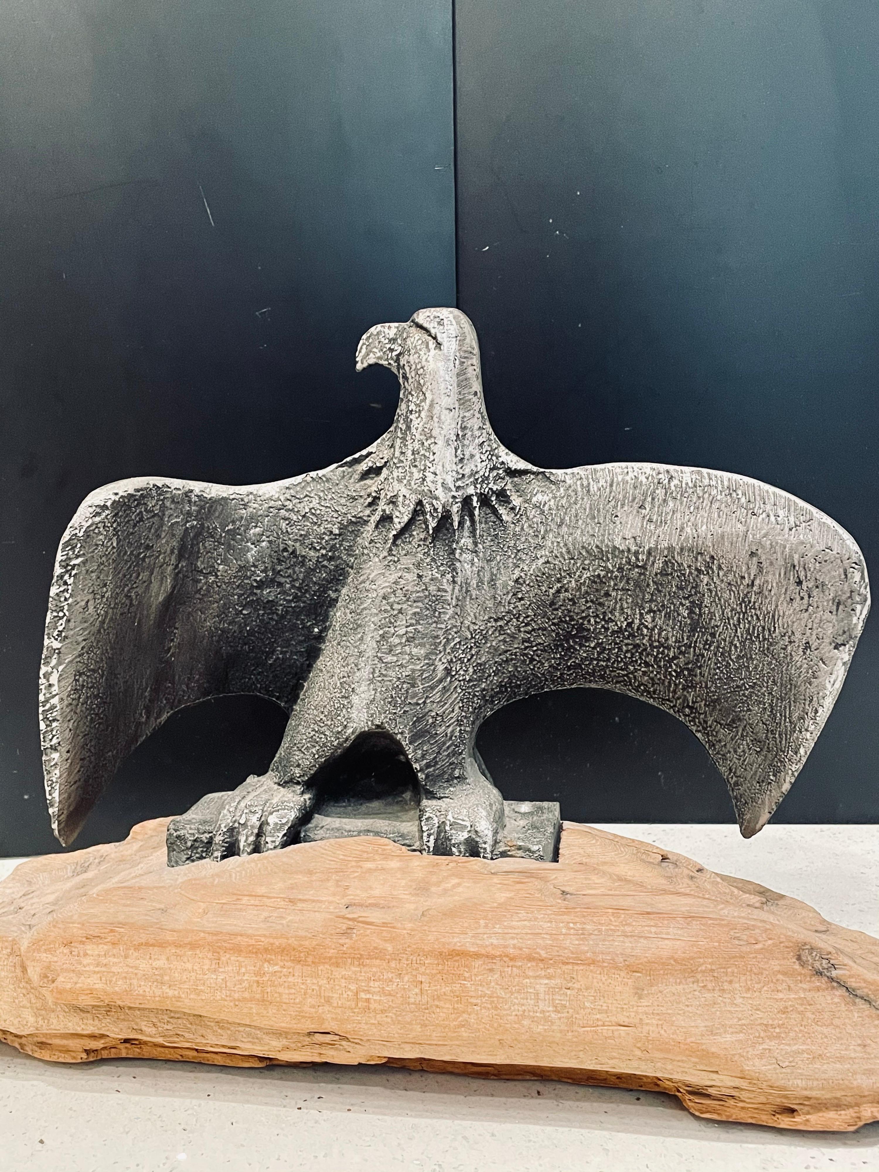 A very interesting American eagle sitting on driftwood log, solid cast aluminum after Don Drumm.