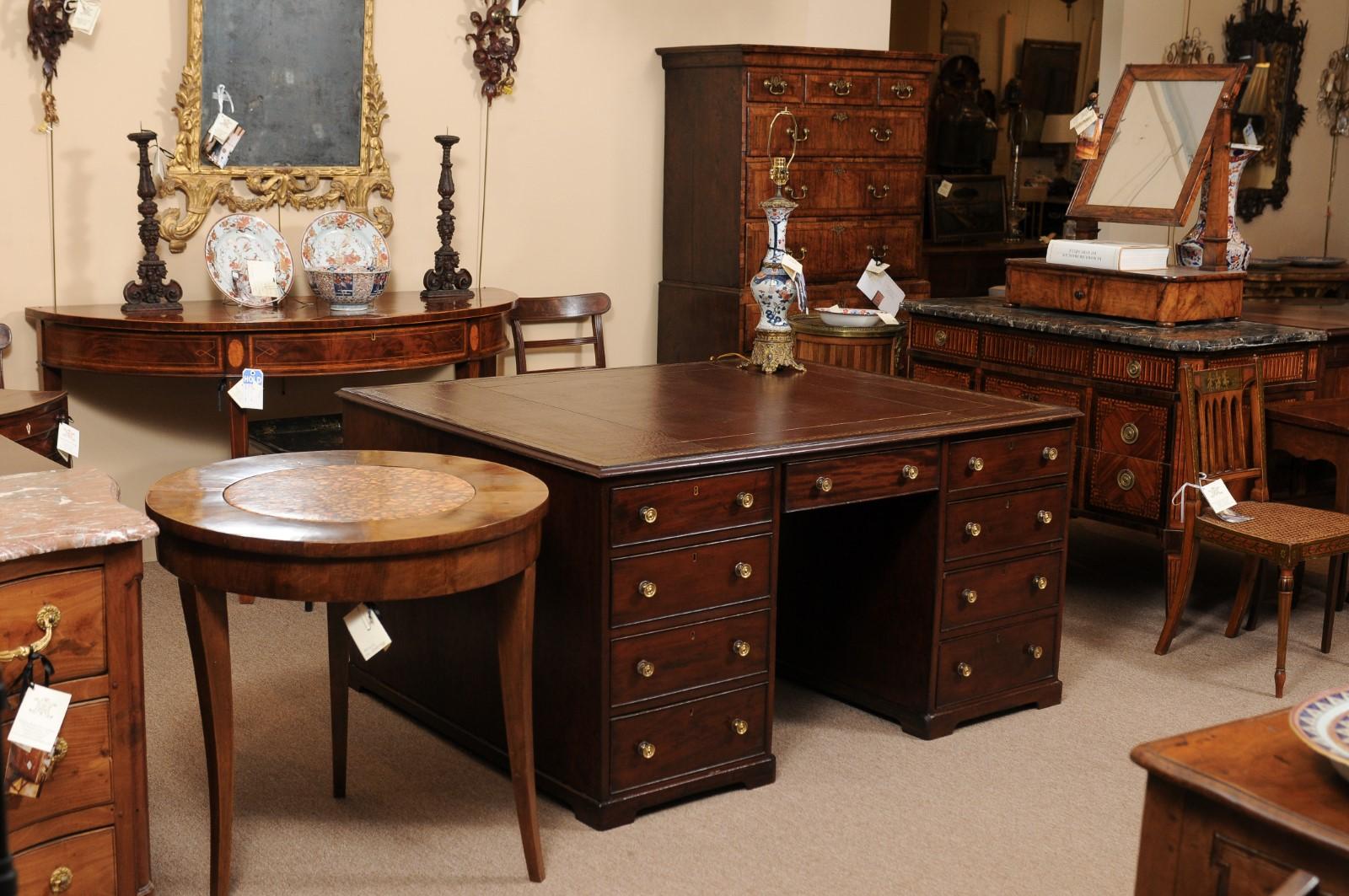 An early 19th century American mahogany partner's pedestal desk featuring embossed brown leather top, moulded edge and 8 drawers below with center knee hole.

 