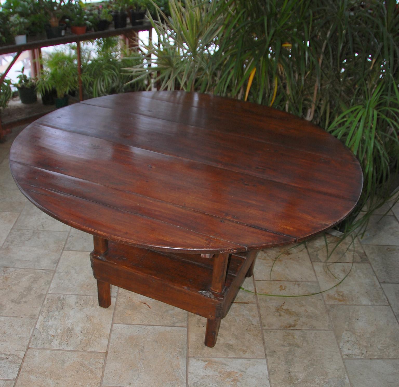 American Colonial metamorphic table chair in pine. This 48 inch round table was a practical answer to making two things for the price of one and making a small room more flexible. When one wanted to use a table for eating or working, the table top