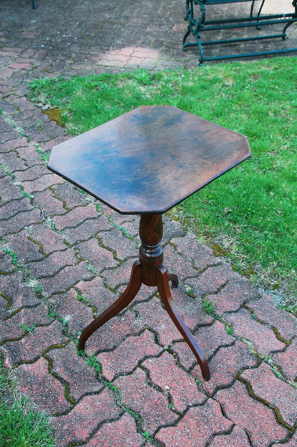 American early 19th century mahogany octagonal tripod candle Stand. This tilt top table is supported by a hand turned stem and concave legs. The small size makes it a perfect table for next to a chair or sofa where space is a consideration. This