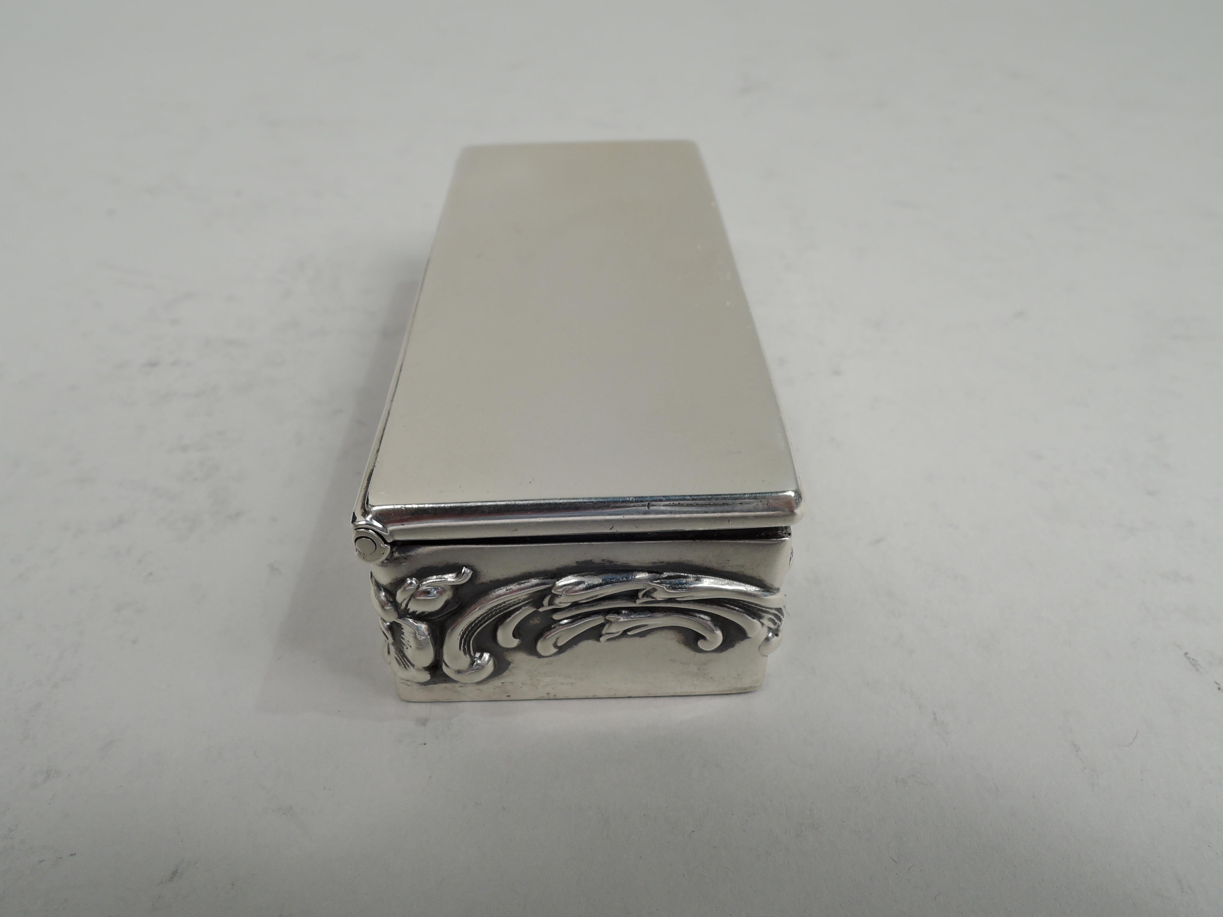 Edwardian Art Nouveau sterling silver postage stamp box. Made by Lebkuecher in Newark, ca 1910. Rectangular with flat and hinged cover. Sides have embossed scrolls and flowers. Interior gilt, partitioned, and curved for 3 denominations. Fully marked