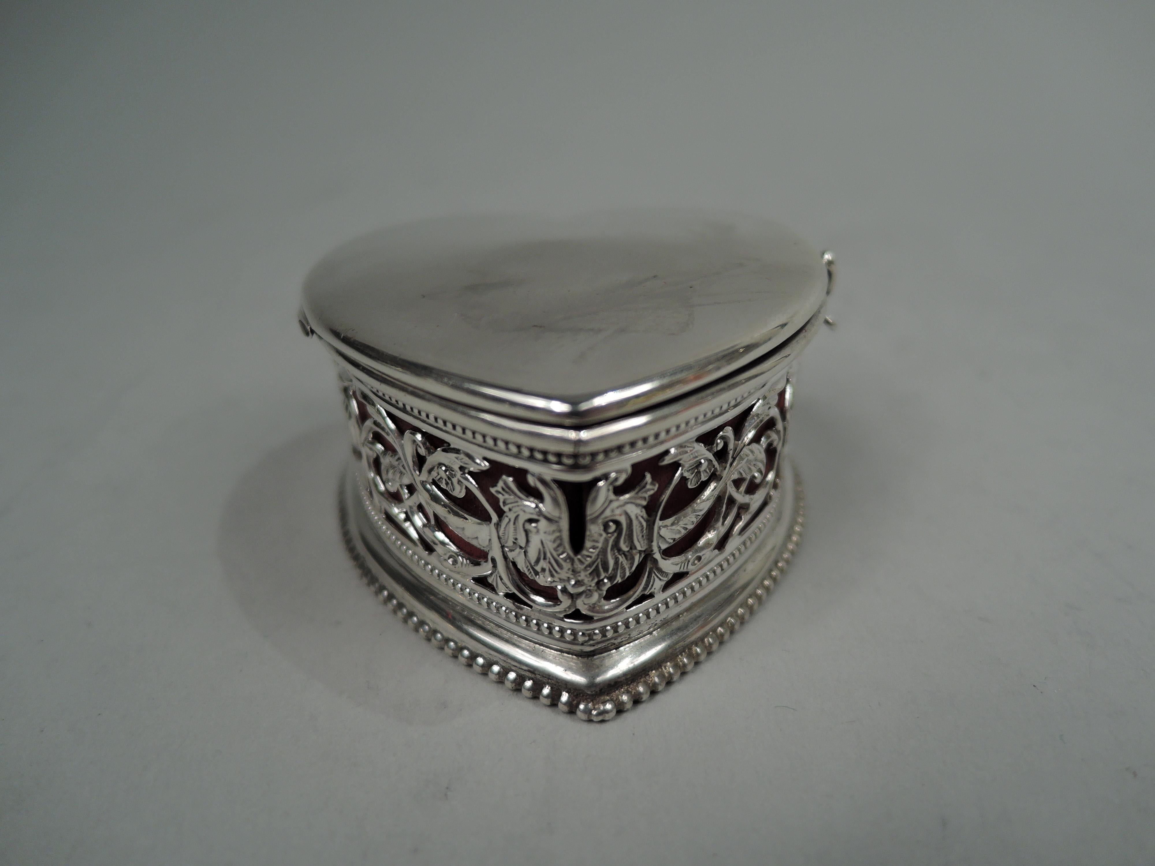 Edwardian Classical sterling silver ring box. Theodore W. Foster & Bro. in Providence, ca 1910. Heart shaped with open leafing scroll sides. Beading. Cover side-hinged and flat with room for engraving. Interior lined with red silk. Fully marked