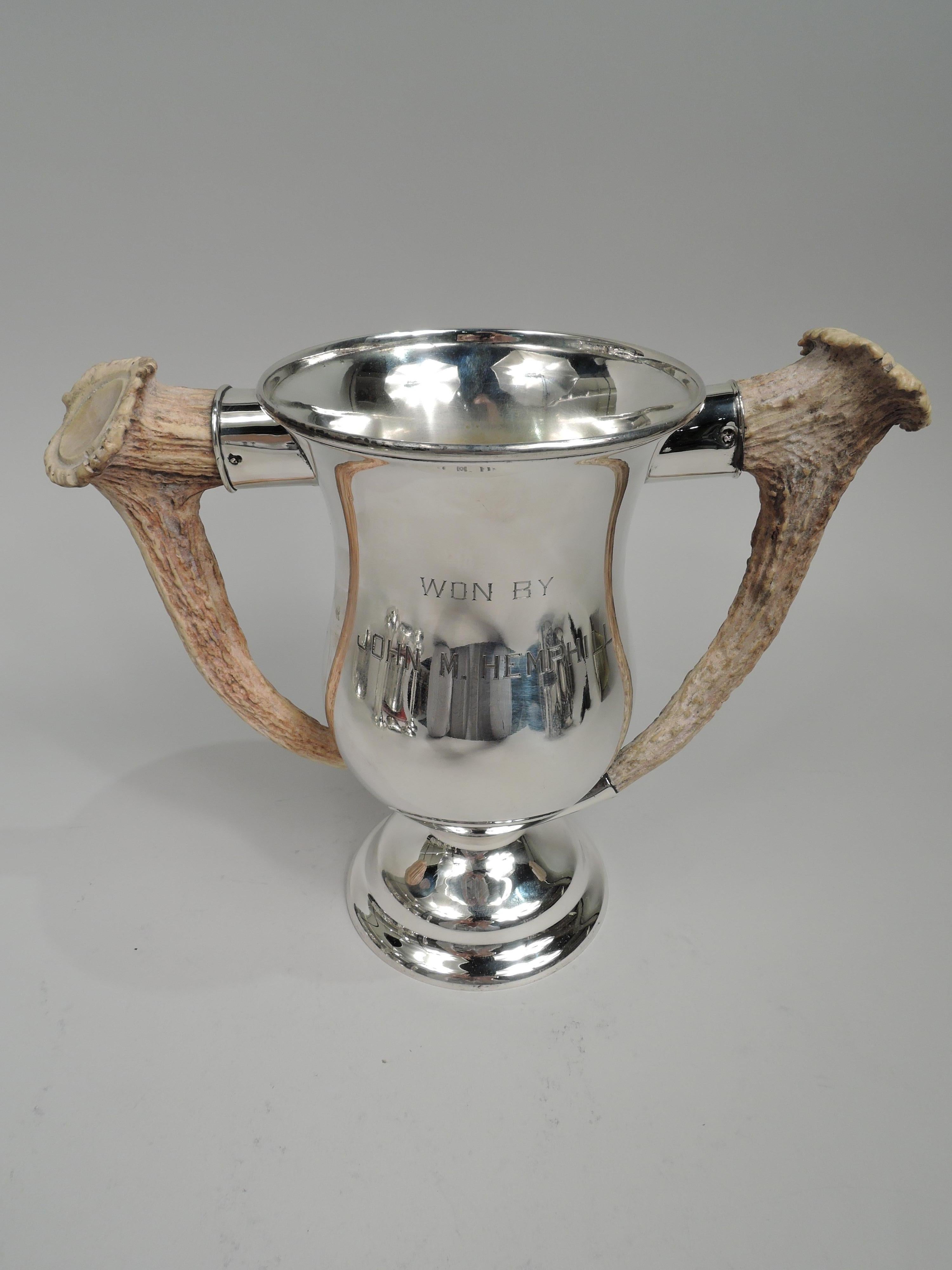 Edwardian sterling silver trophy cup, ca 1910. Baluster bowl with silver-mounted horn side handles; domed foot and gilt-washed interior. On front is engraved presentation: “James C. Brooks / Memorial Cup / Ideal Score for Men May 1st To Oct. 1st