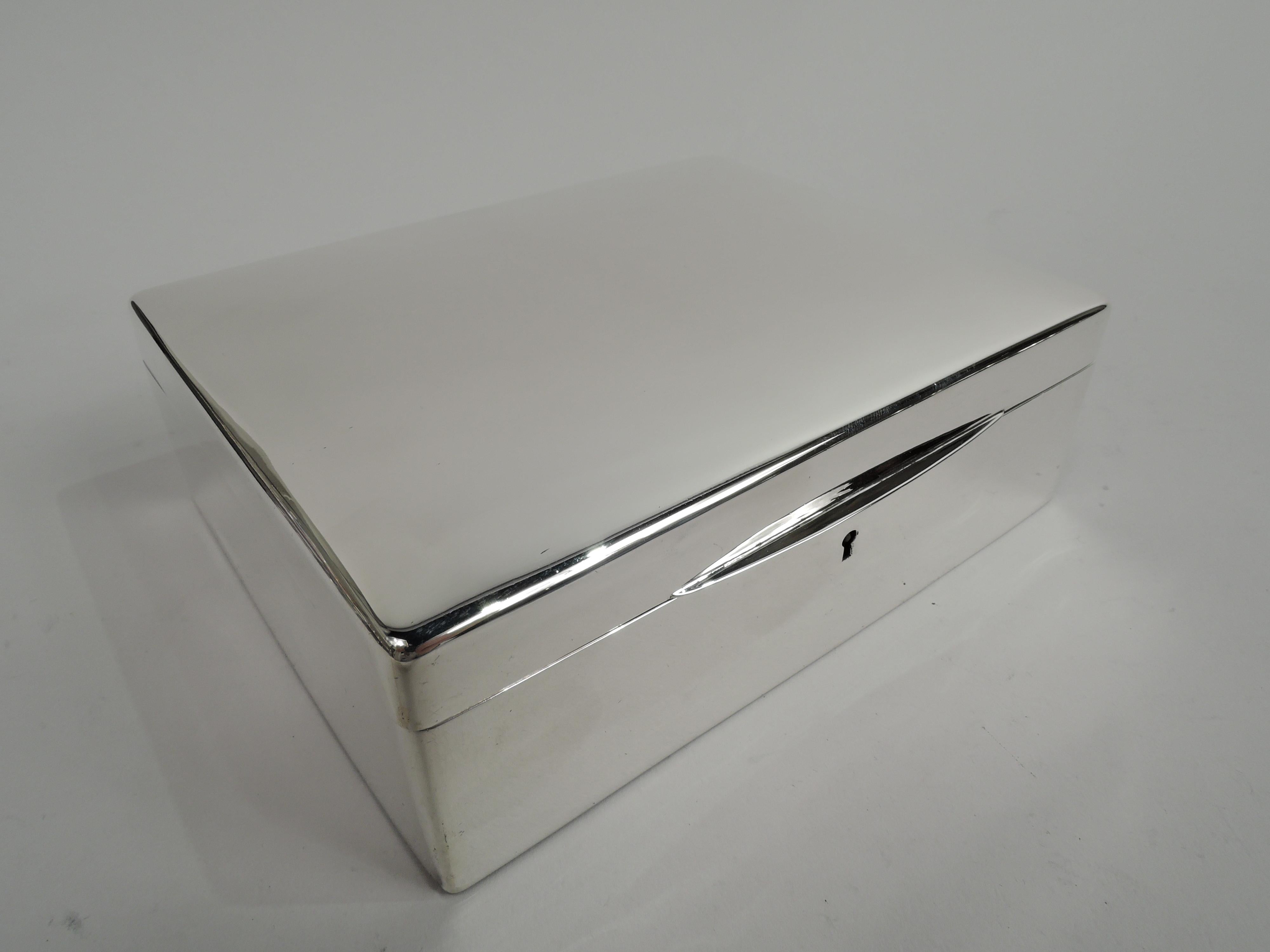 Edwardian Modern sterling silver jewelry box. Made by Woods & Chatellier in New York, ca 1910. Straight sides with curved corners. Cover hinged with gently curved top and tapering tab. Keyhole with key. Velvet lined interior for the heirloom bits.