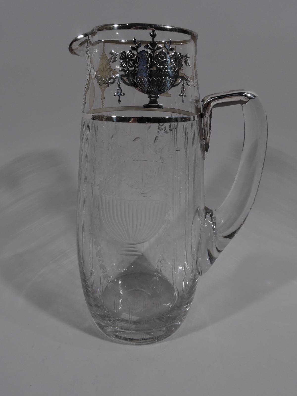 Pretty antique American Edwardian Regency Revival drink set in clear glass with silver overlay, circa 1910. This set comprises 1 pitcher and 8 glasses. Pitcher ovalish with small lip spout. Scroll bracket handle with silver CAP. Acid-etched stylized