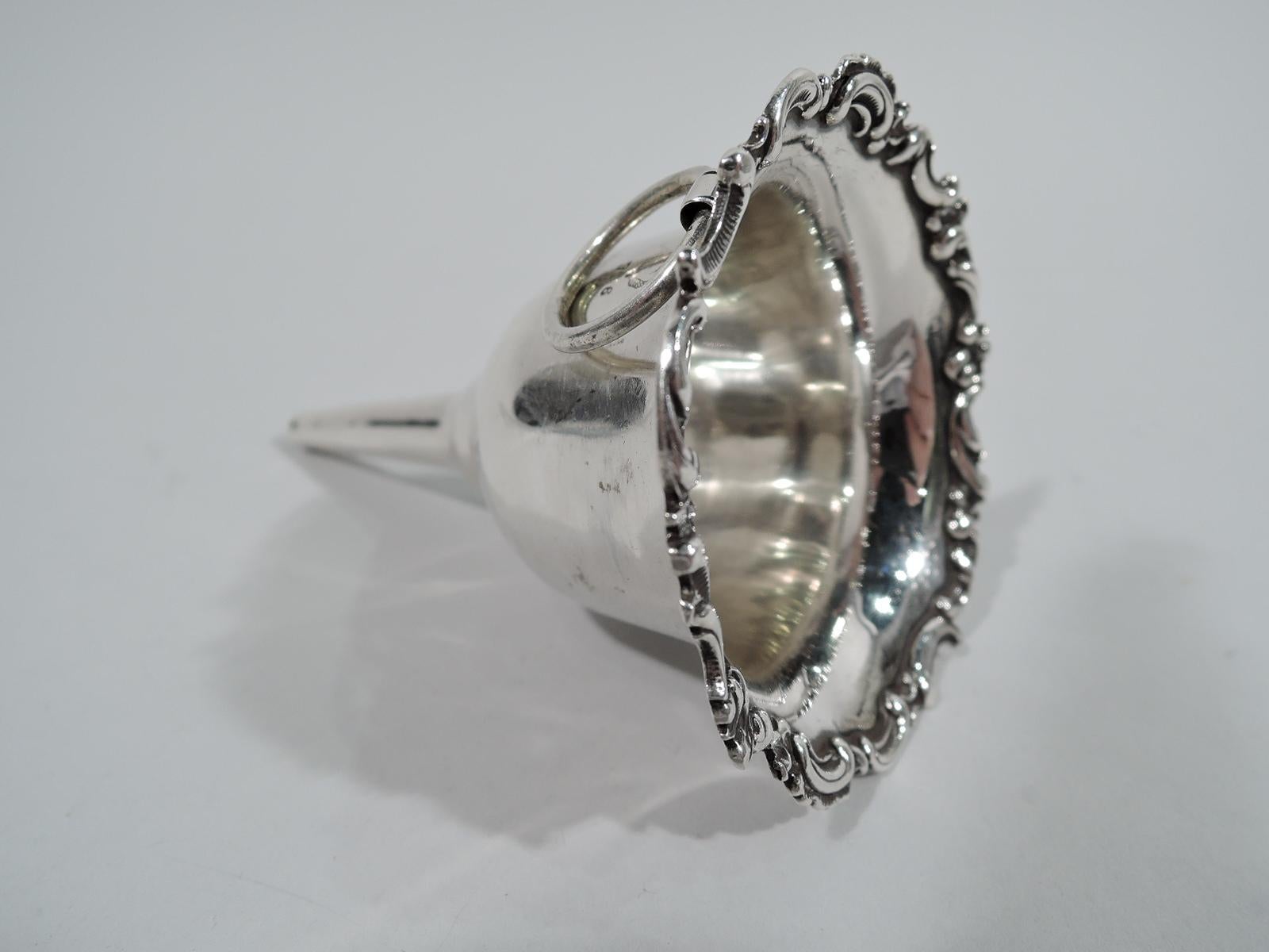 Edwardian sterling silver wine funnel. Curved and tapering body with scrolled rim and straight and tapering spout. Small size suitable for lady’s night with loose-mounted ring that can be conveniently attached to a chatelaine or key ring. Fully