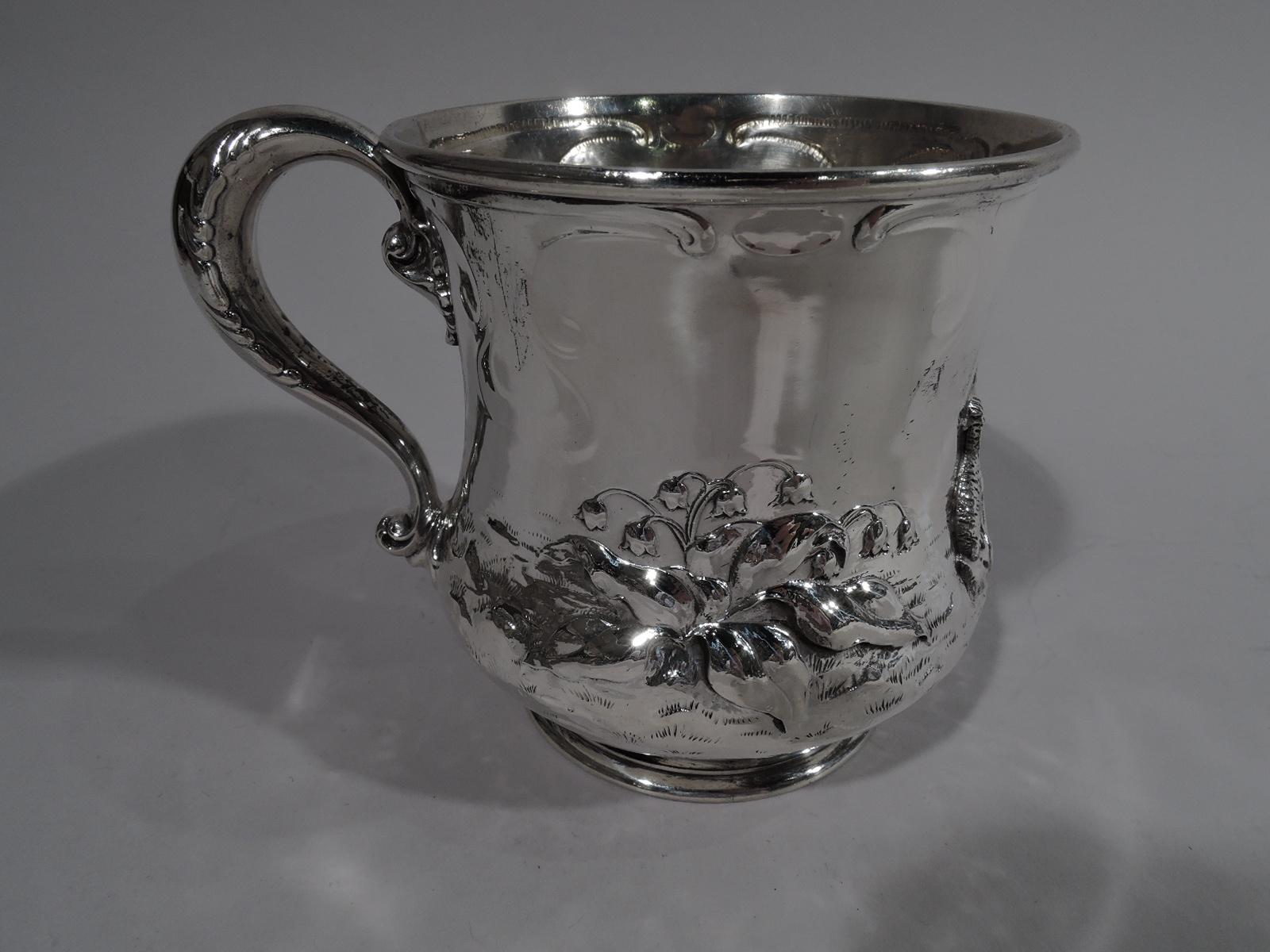 Turn-of-the-century American sterling silver baby cup. Baluster bowl with short inset foot and S-scroll handle. Chased and applied pastoral scene with hussy shepherdess in tightly-laced bodice and flowery hat sitting cross-legged between lamb and