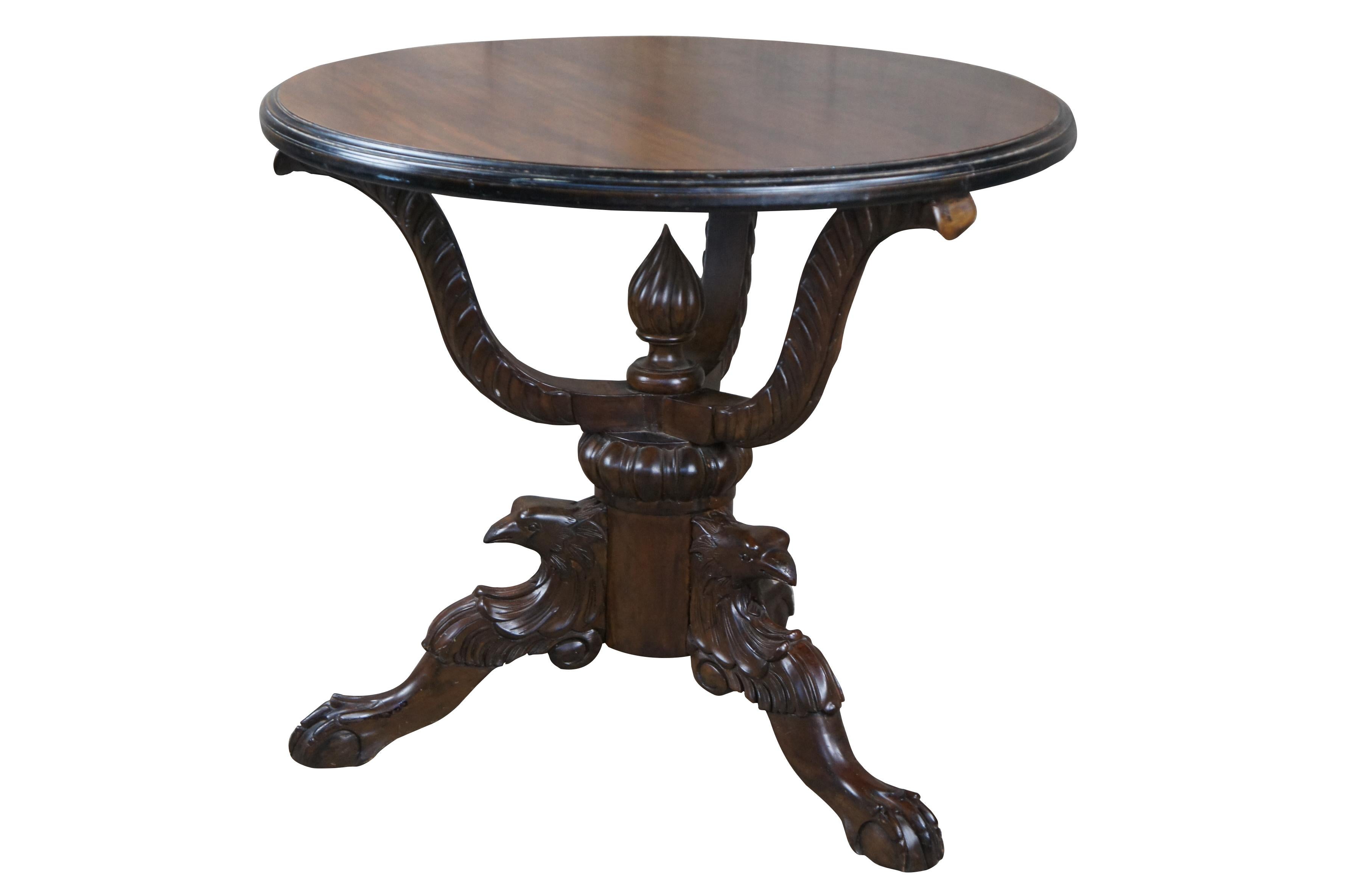 American Empire carved mahogany parlor table featuring round form with tri foot carved eagle legs over ball & claw feet with elaborate serpentine support and center finial. 

Dimensions:
31.5