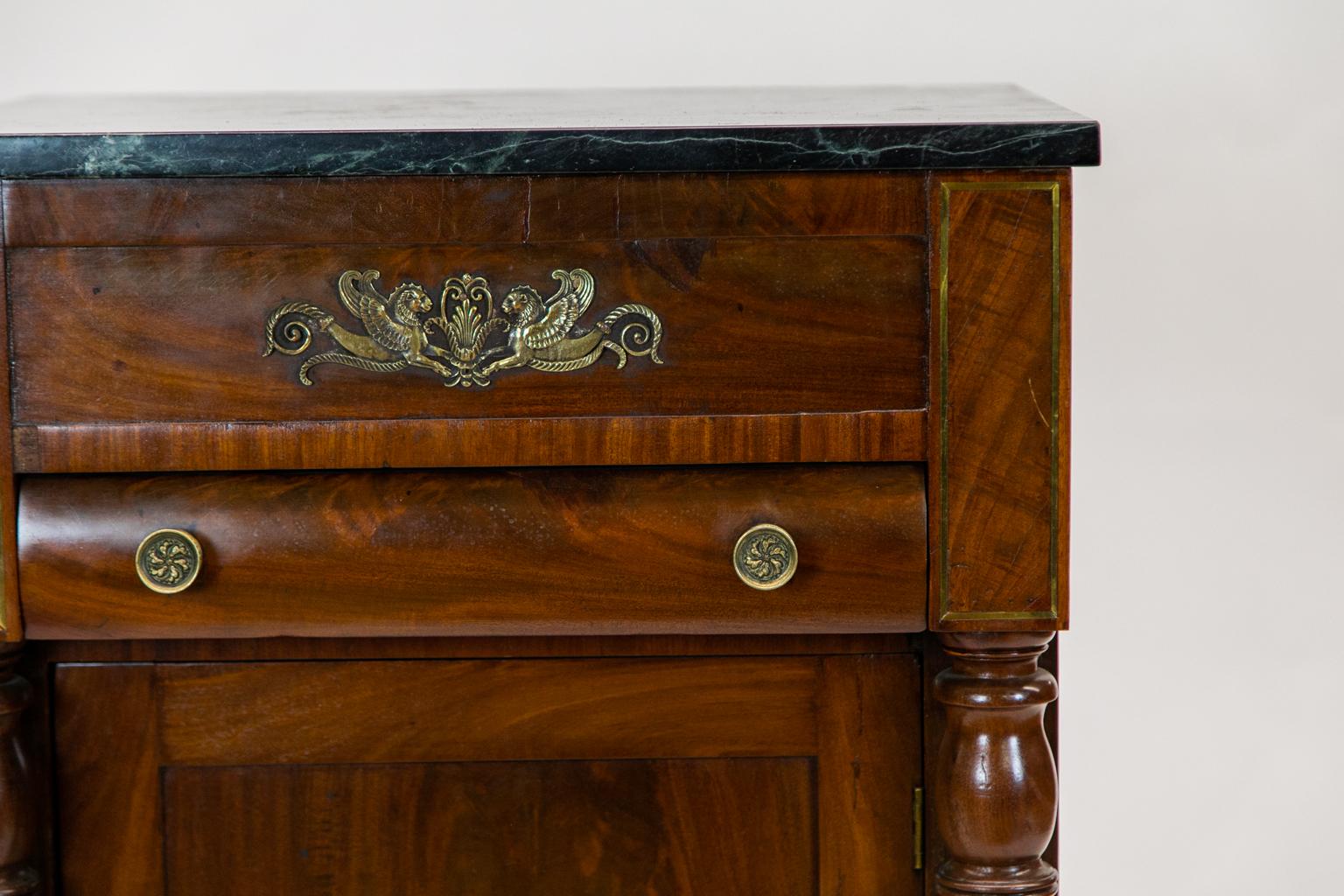 The top of this American Empire console cabinet has a dark green marble(later). The marble can be moved aside to reveal a hidden compartment behind the frieze. The sides have recessed panels.
 