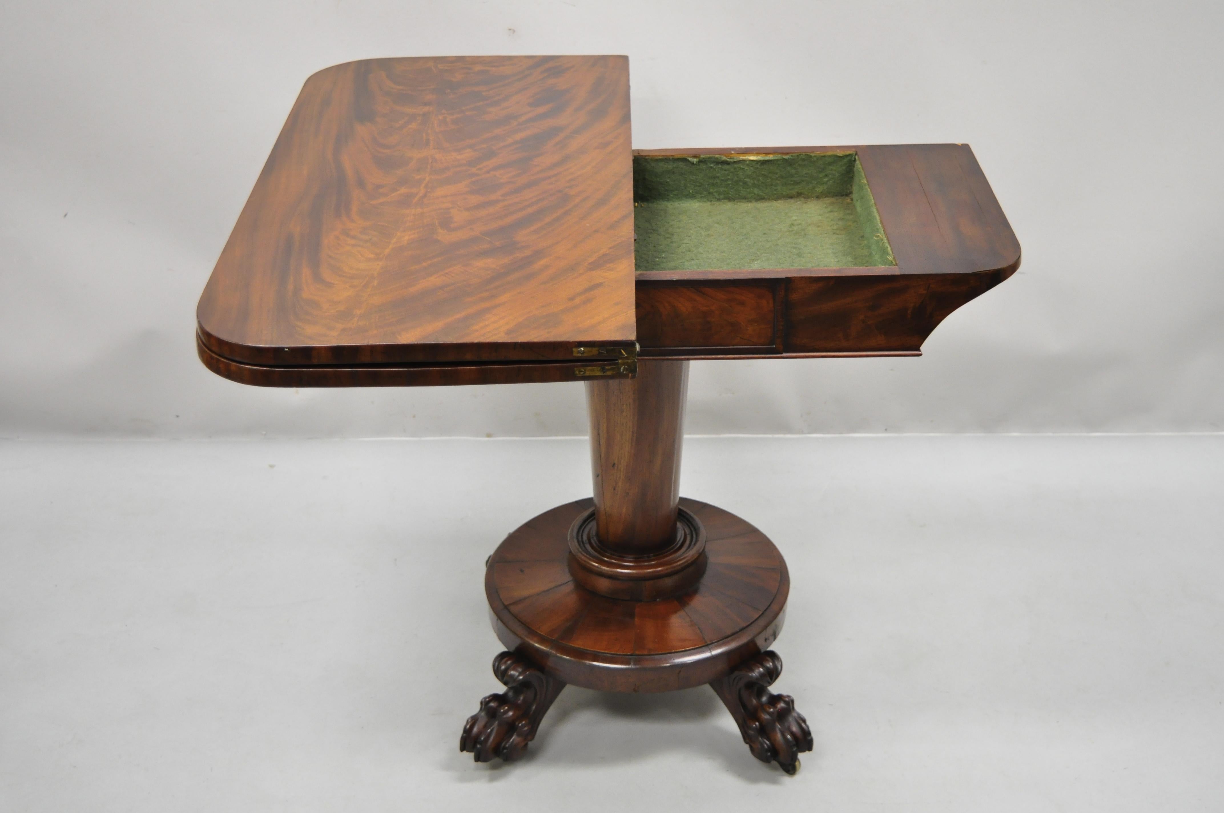 19th century American Empire crotch flame mahogany paw feet pedestal base console game table. Item features swivel and flip top, pedestal base, beautiful wood grain, nicely carved details, carved paw feet, very nice antique item, great style and