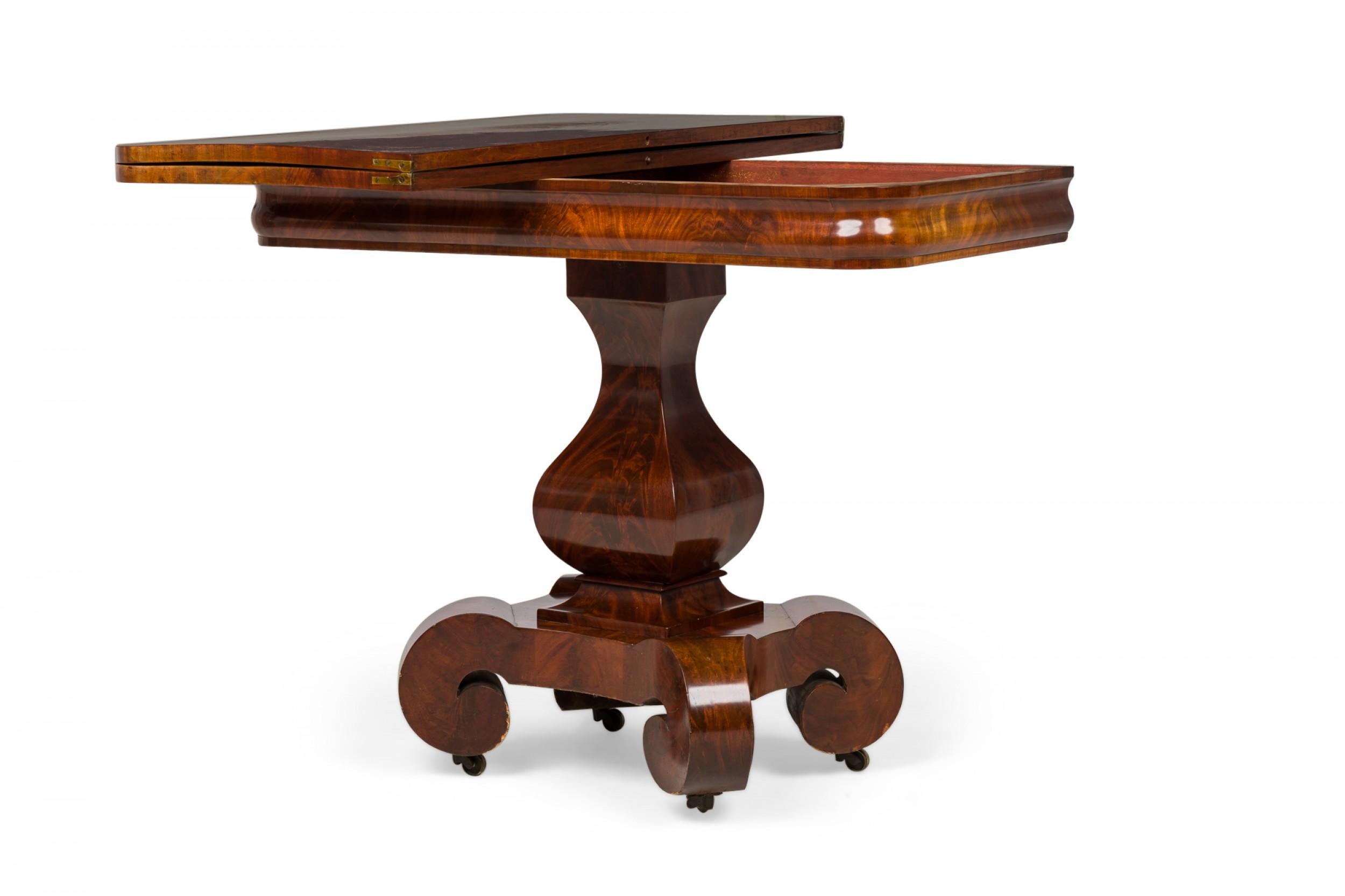 Table d'appoint rectangulaire pliante American Empire avec un plateau coulissant et une feuille articulée extensible, reposant sur une base de piédestal balustre terminée par 4 pieds à volutes aplaties avec roulettes, finie en placage d'acajou.
