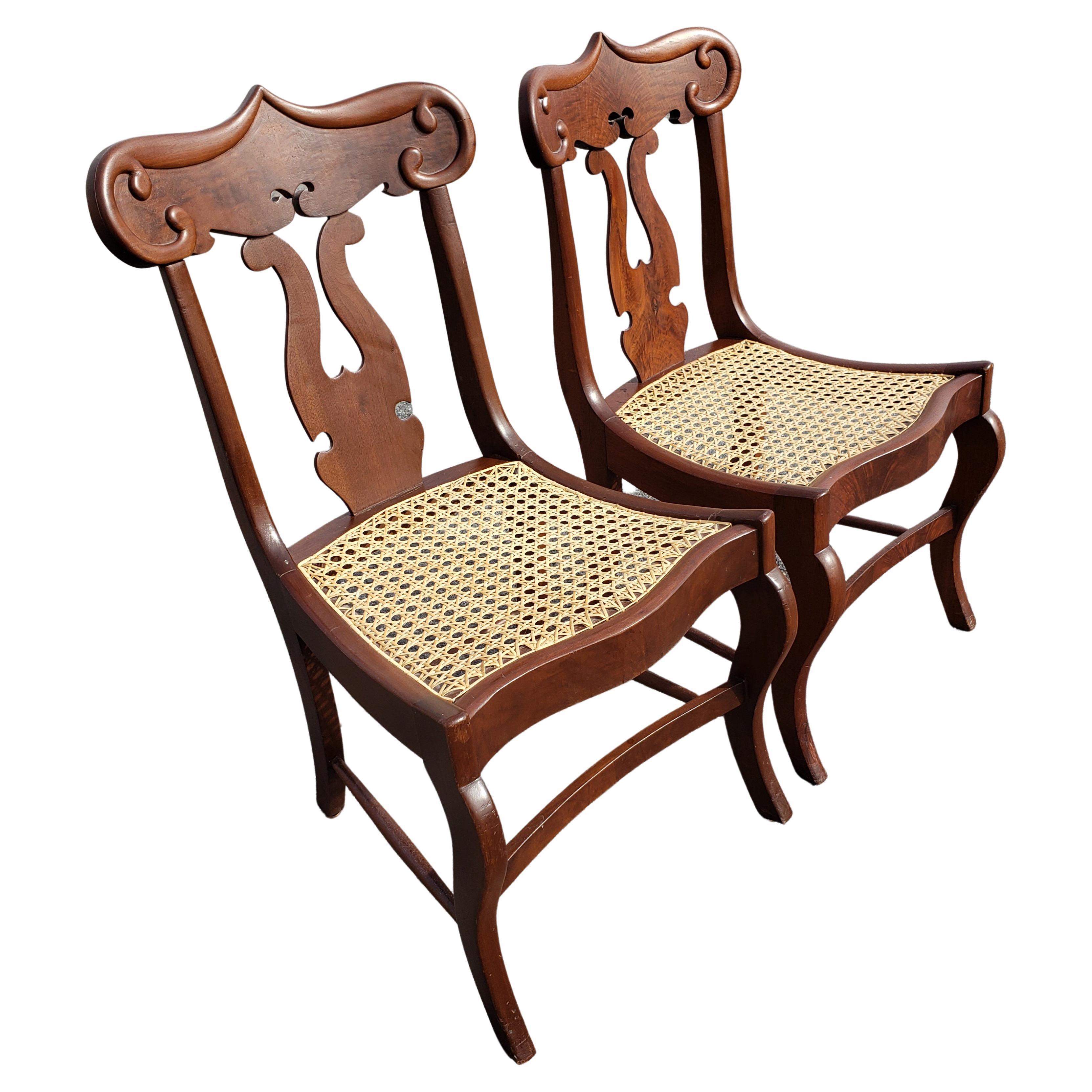 Gorgeous pair of American Empire Flame Mahogany cane seat chairs. Newly caned seats. 
Excellent condition. 
Measure 17.5'W x 19' D x 32.75
