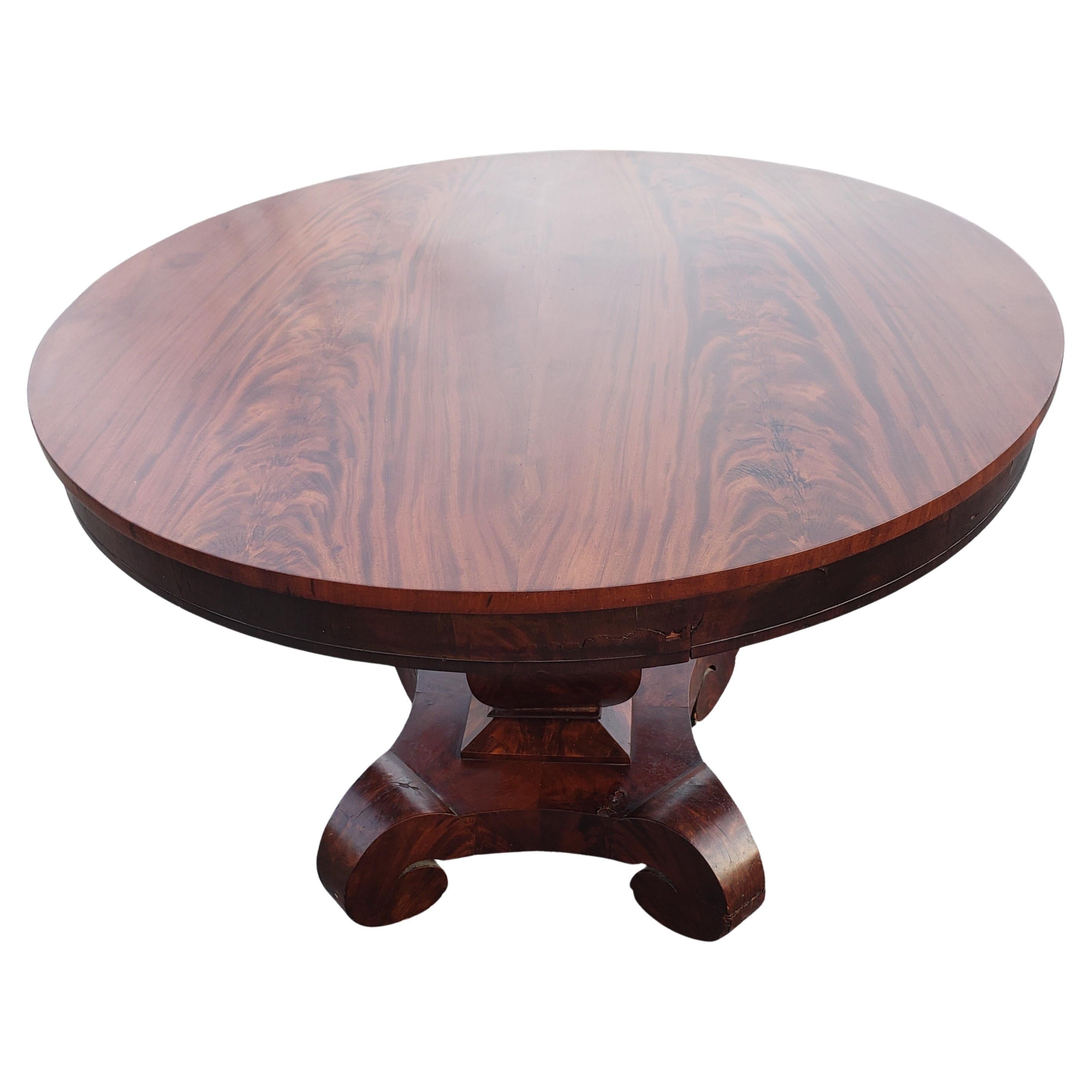 We are pleased to offer this gorgeous Antique American Empire center table, from the 1840s .
This Table is made of Mahogany wood, featuring round flame Mahogany Veneer top , and supported by sturdy column ending with 4 legs on origianal