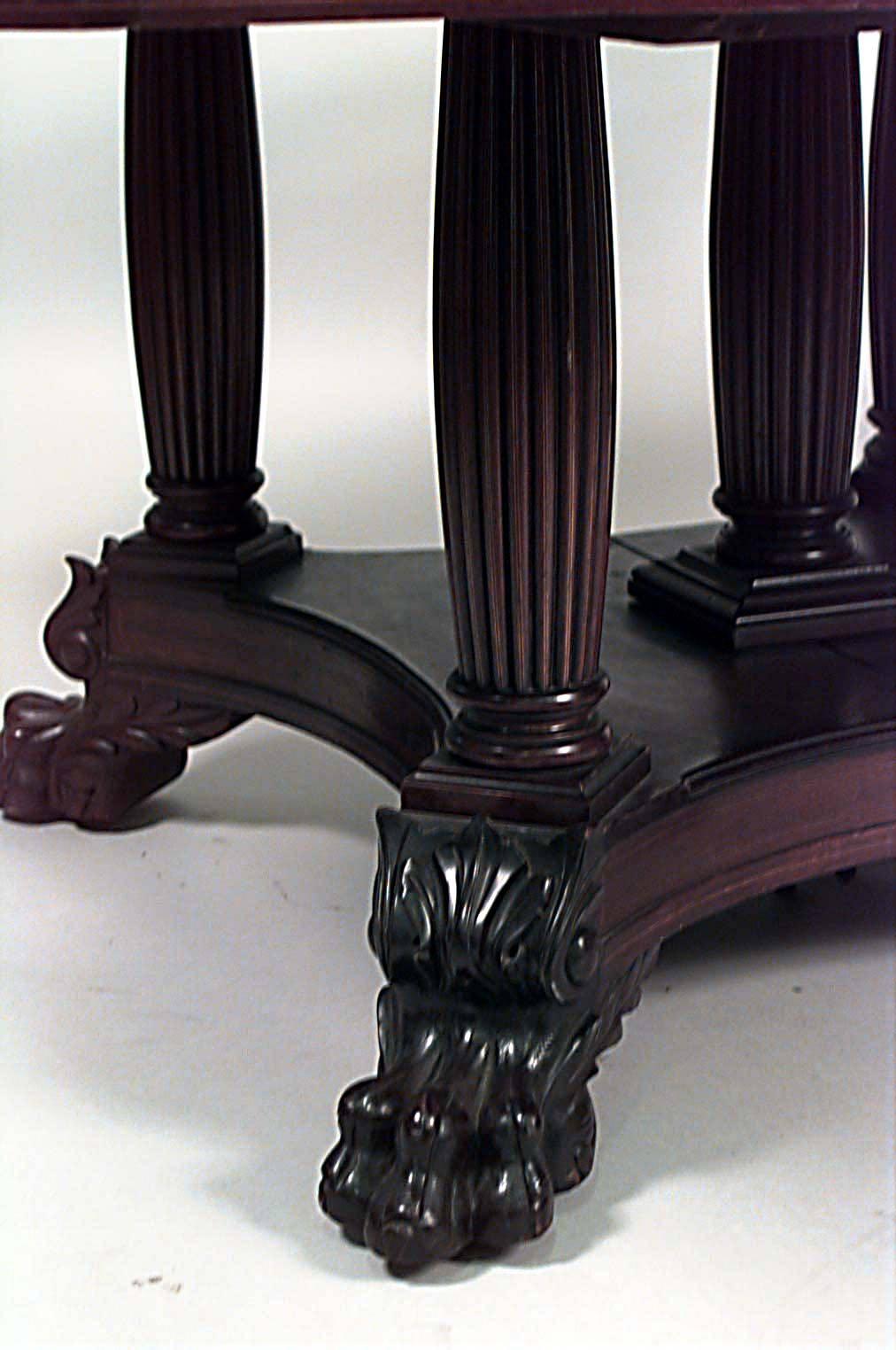 American Empire mahogany square dining table with an inlaid border and raised on fluted legs over a platform base with claw feet.
