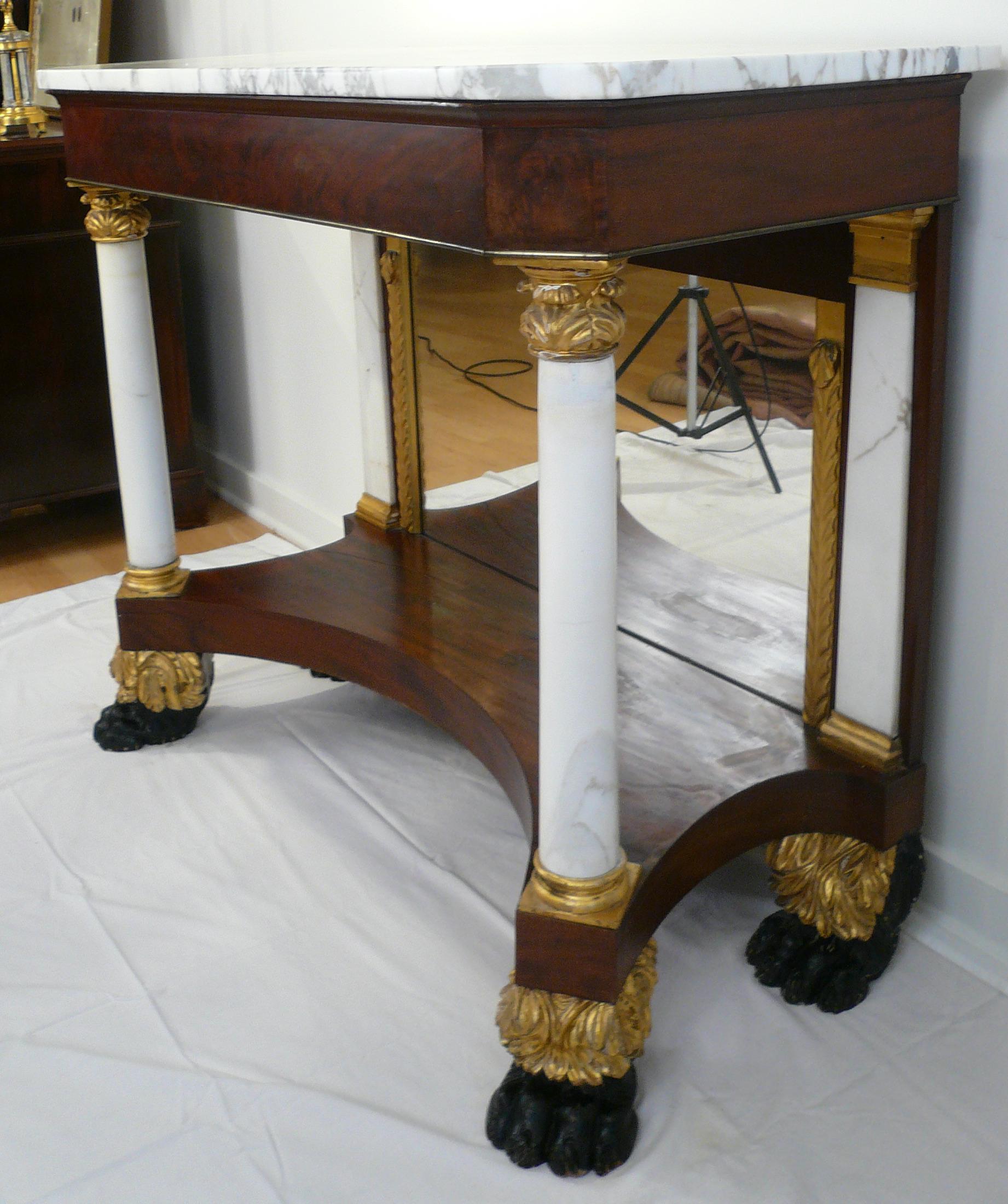 This American Classical pier table, was made in New York circa 1820.
Retaining its original marble top and mirror, the table has white marble columns and pilasters, with carved gilt wood capitals and bases.
The hairy paw feet are accented by gilt