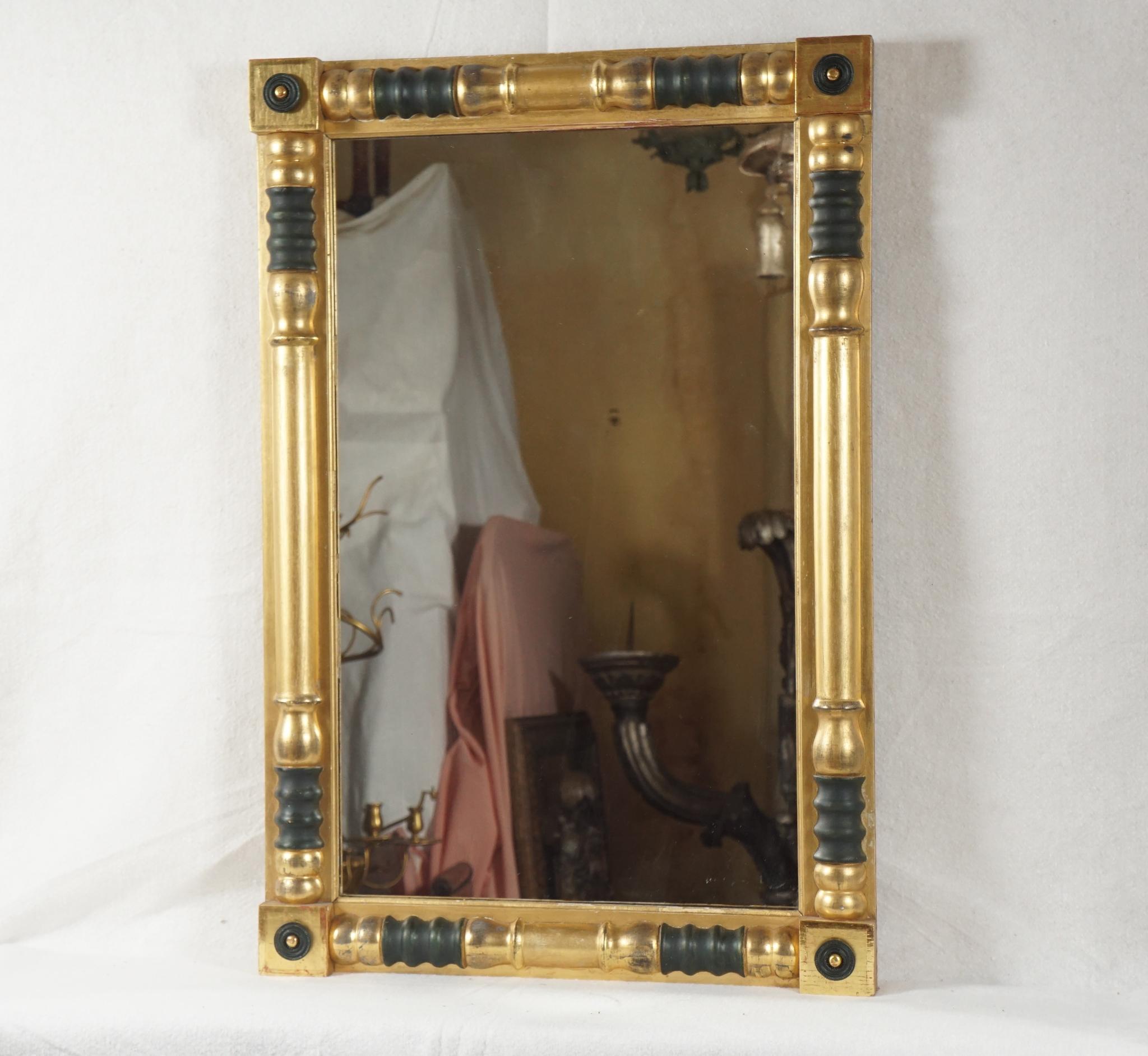 This very good American Empire gilt and painted wood mirror is of the period circa 1825-1835 was made in New York State and is in almost perfect condition. The standard format of turned and ring divided shaped columns is set onto a flat ground