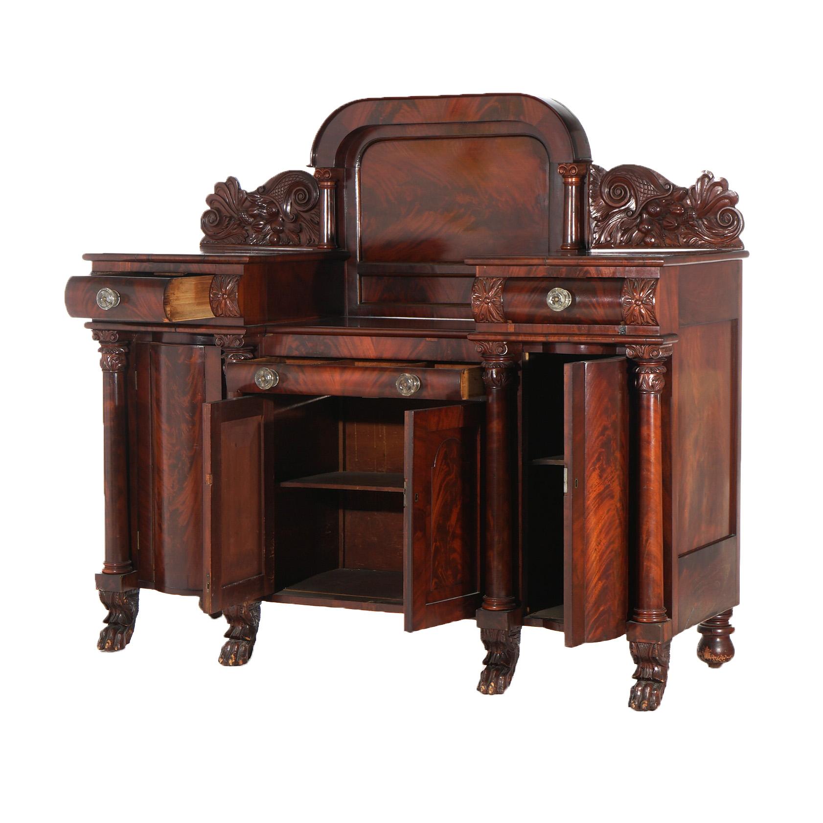 ***Ask About Reduced In-House Delivery Rates - Reliable Professional Service & Fully Insured***
An antique Greco American Empire sideboard attributed to Quervelle offers flame mahogany construction with Neoclassical elements including Greco-Roman