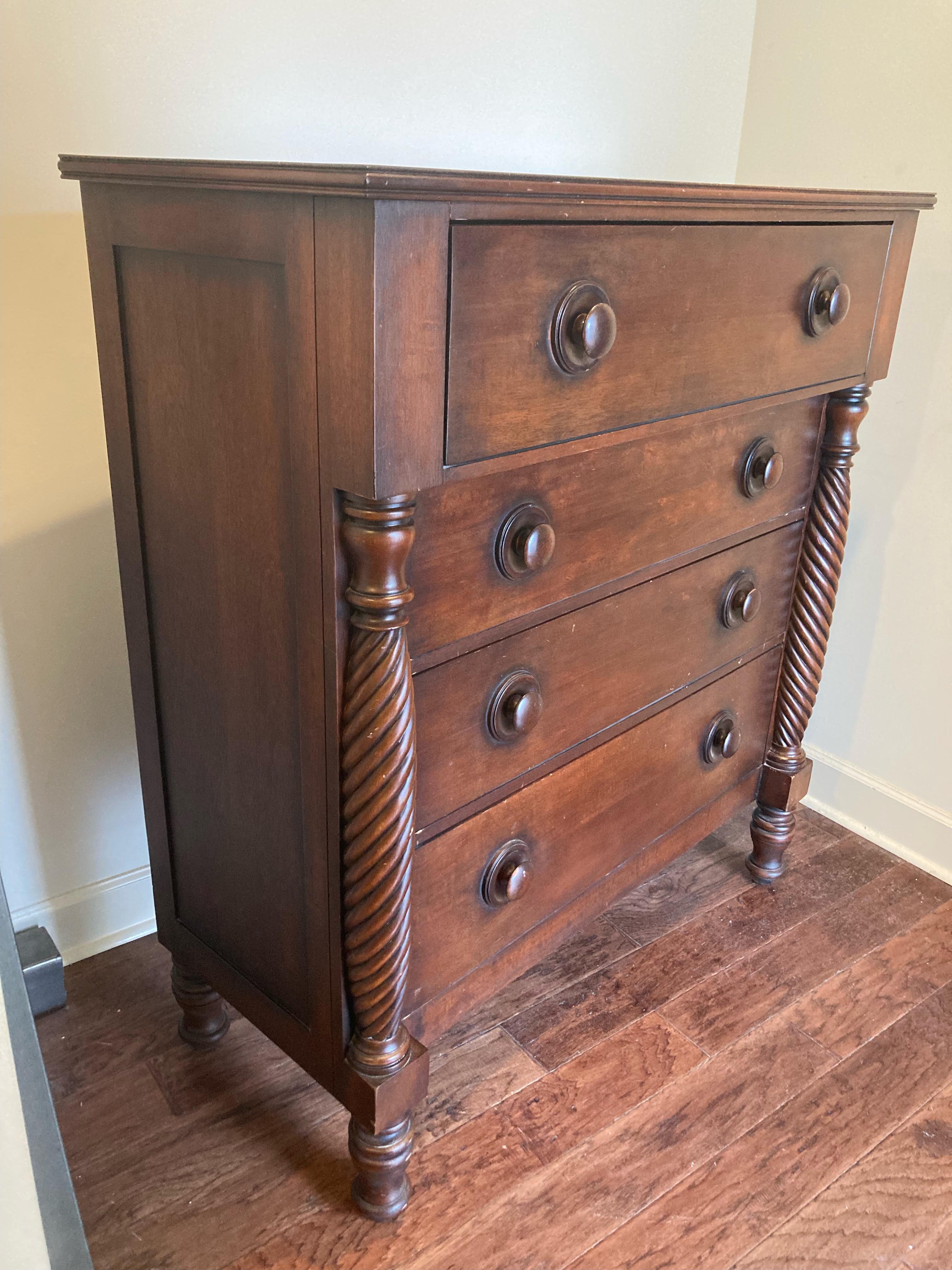 A gorgeous mahogany American Empire style four drawer highboy dresser chest
with carved columns and turned legs.