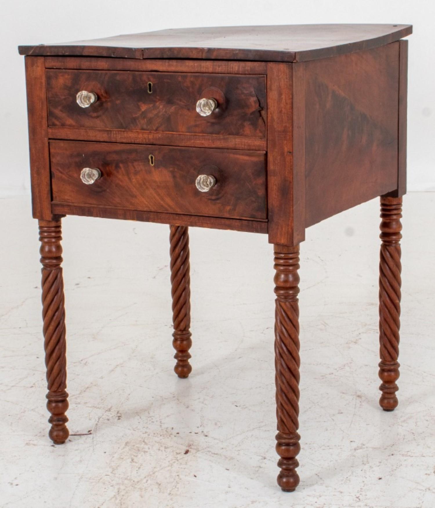 American Empire flame mahogany side table with two drawers above four twisted legs, with later cut glass pulls.

29 inches in height, 21.25 inches in width, and 19 inches in depth.