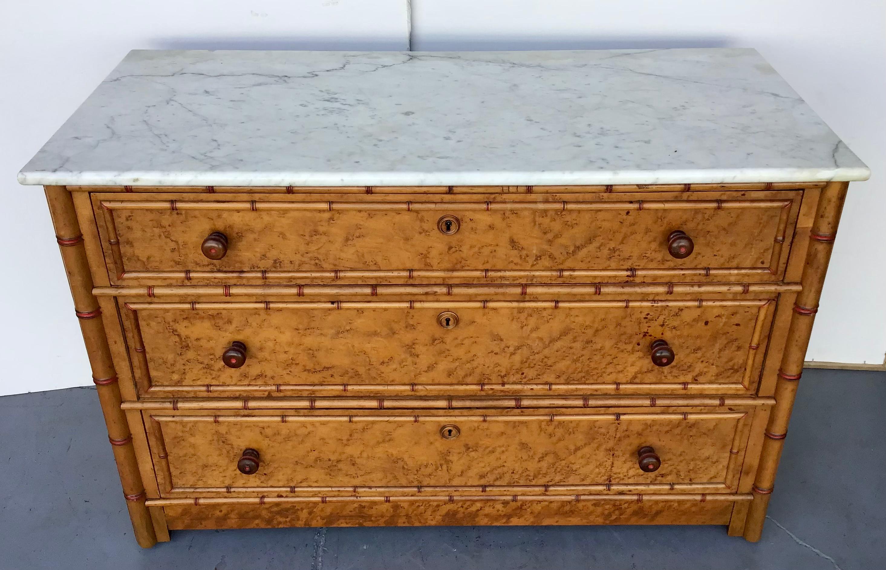 American faux bamboo chest attributed to horner. Three drawer chest with original faux bamboo handles, birds eye maple wood and original wood casters. White Marble Top.