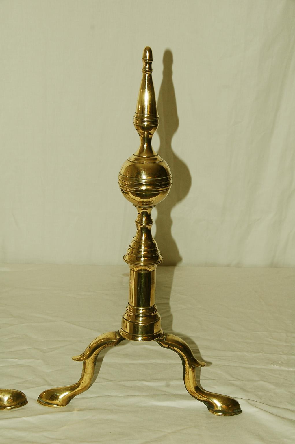 American Federal period brass ball and steeple top andirons. The belted balls are surmounted by a spire that adds height and elegance to these early 19th century andirons. The belted ball and spire are supported by a round column that sits upon