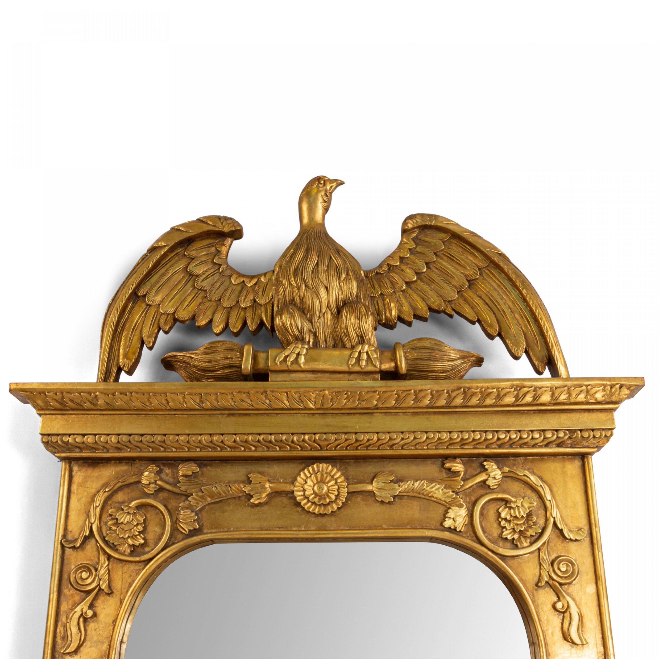 American Federal style (20th Century) large carved giltwood wall mirror with carved eagle pediment, scroll detail, and two decorative columns featuring five-pointed stars.
 