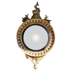 Miroir convexe à feuillage de dauphins doré et ébénisé, de style fédéral américain. Années 1800