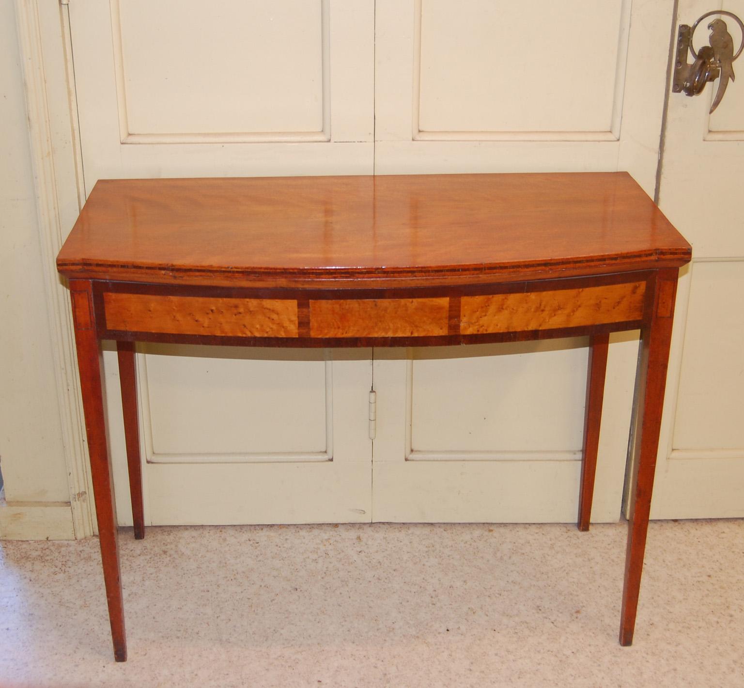  American Federal 18th Century Portsmouth, New Hampshire tea table with elegant tapered legs and breakfront bowfront folding top.  This foldover Hepplewhite tea table opens up supported by one swing leg  to seat four people for tea or games. The