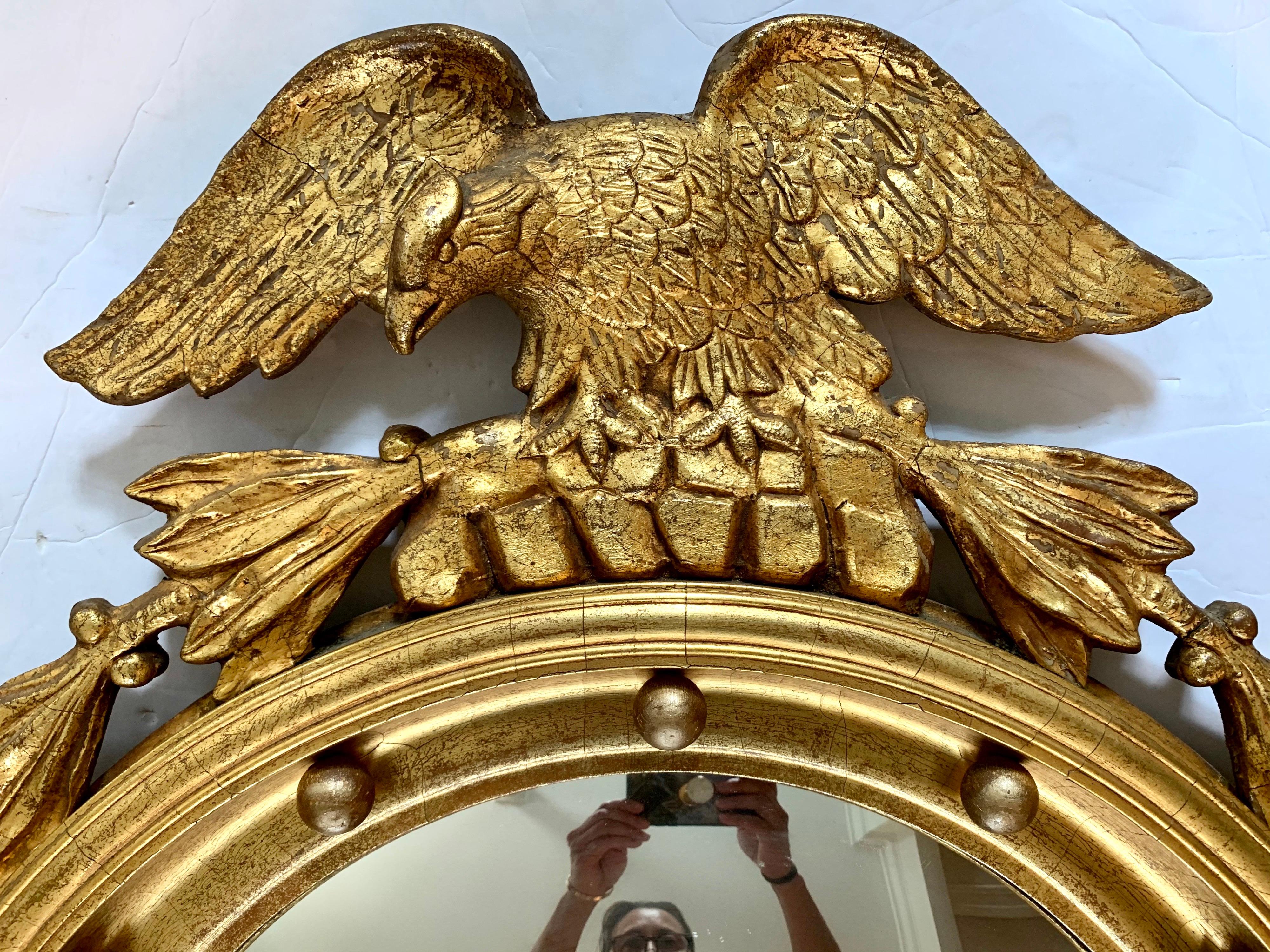 American Federal gilt convex wall mirror with ball design, fluted border, and eagle top, circa late 19th century, USA. Real giltwood, not resin.