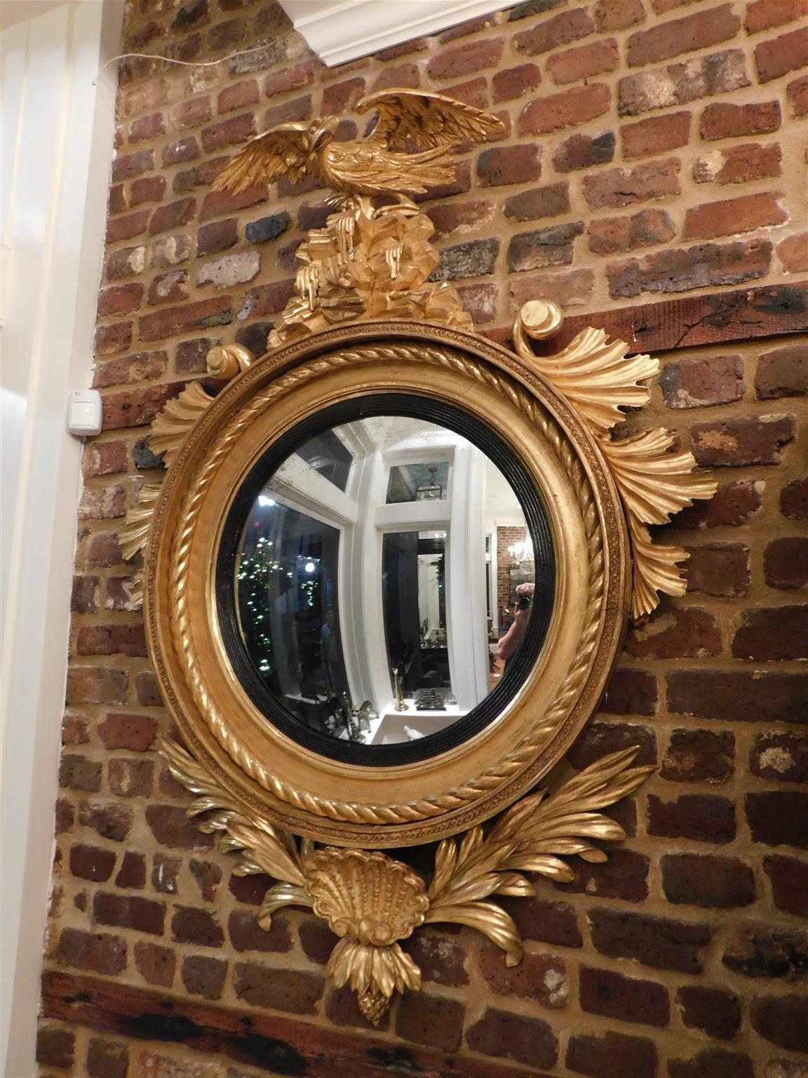  Monumental Period American Federal gilt wood and gesso convex mirror with a central spread winged Eagle perched to flee on rocky plinth, upper flanking scrolled acanthus foliage, interior gilt rope border with ebonized reeded ring, and lower