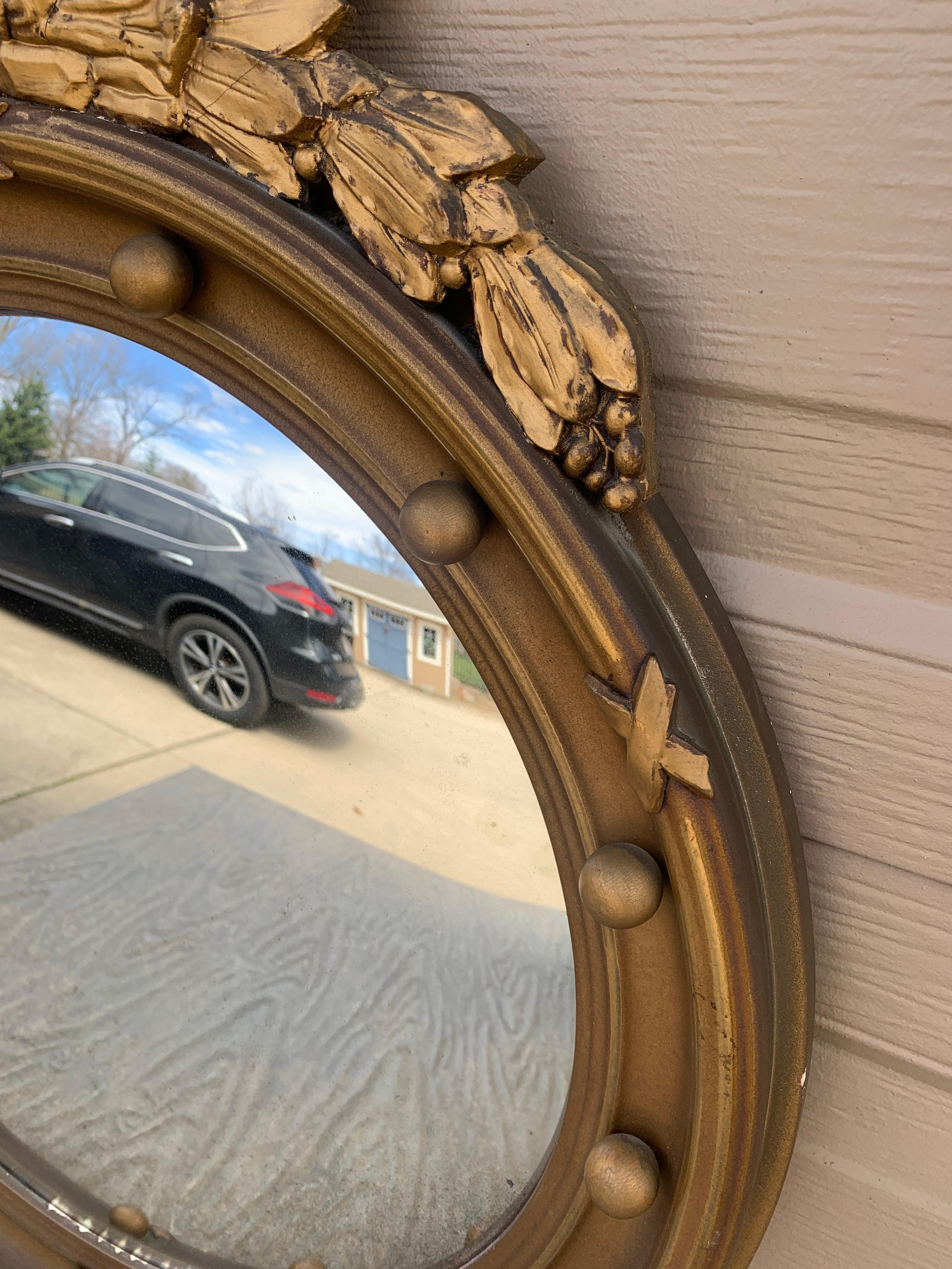 A gorgeous Federal or Regency style convex bullseye wall mirror featuring a carved eagle with open wings standing on olive branches and 13 small spheres representing the original 13 colonies around the inside perimeter.

USA, Mid-20th