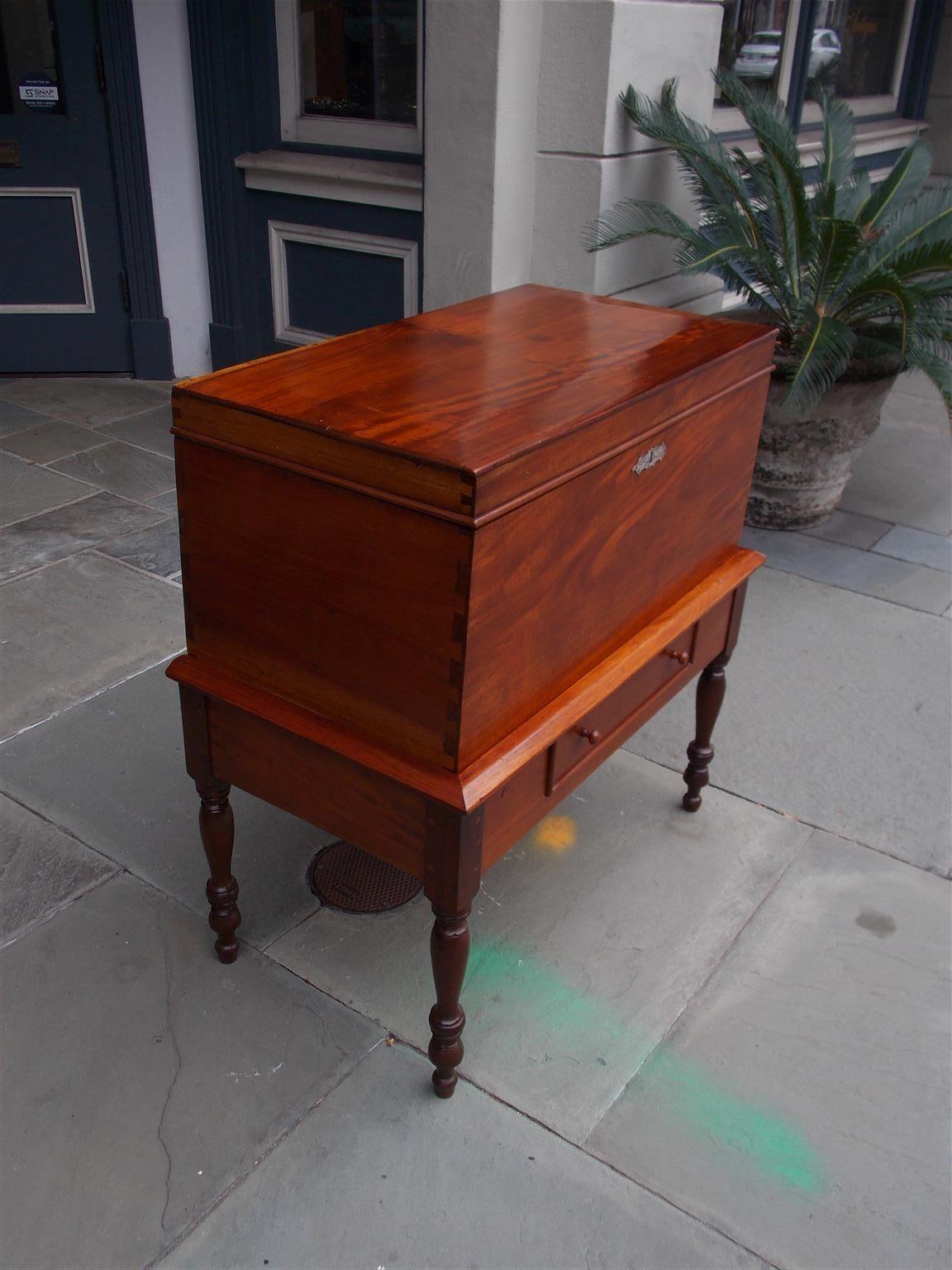 American Federal mahogany and Spanish cedra one drawer hinged sugar chest on stand with carved molded edge, exposed dovetails, wooden knobs, silver escutcheon, original keys, and resting on the original turned bulbous ringed legs, Early 19th
