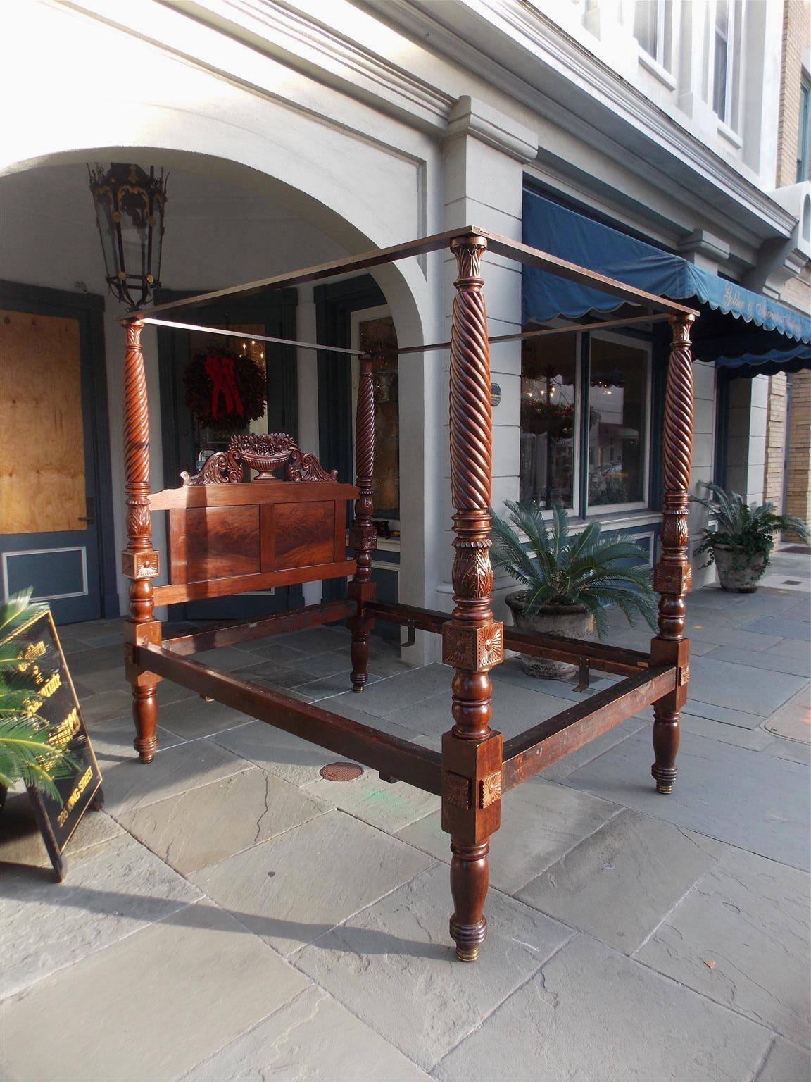 American Federal mahogany four poster tester / finial bed with a carved book matched headboard consisting of a basket of fruit and flowers, turned bulbous rings, carved barley twist and acanthus post, foliage medallions, and resting on brass ringed