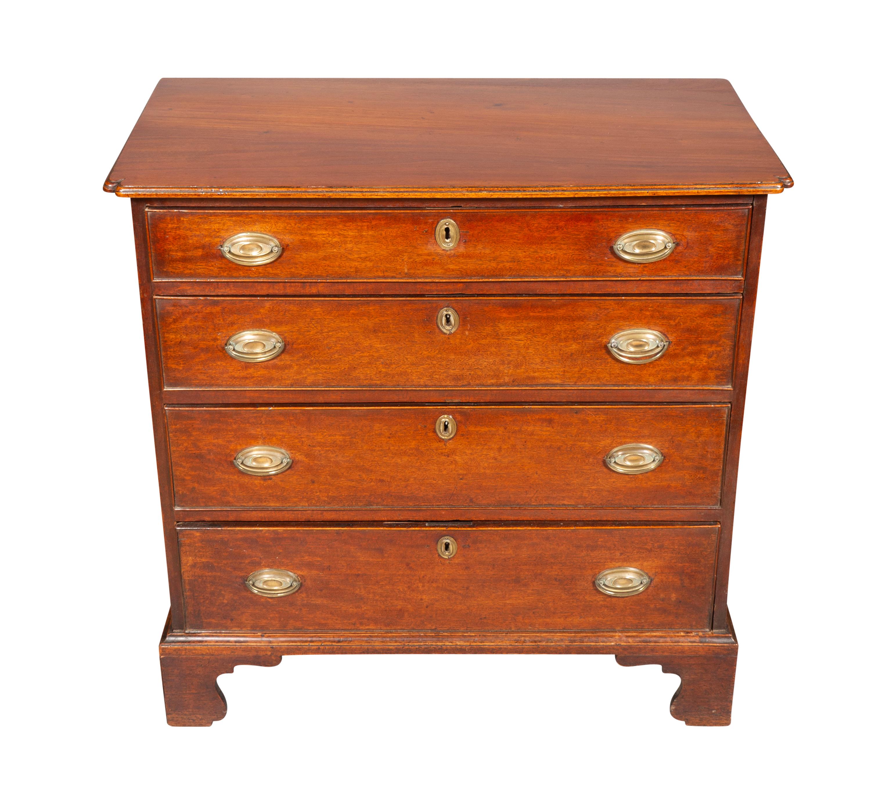 Rectangular top with pinched corners over four graduated drawers with oval brass handles.
Bracket feet.