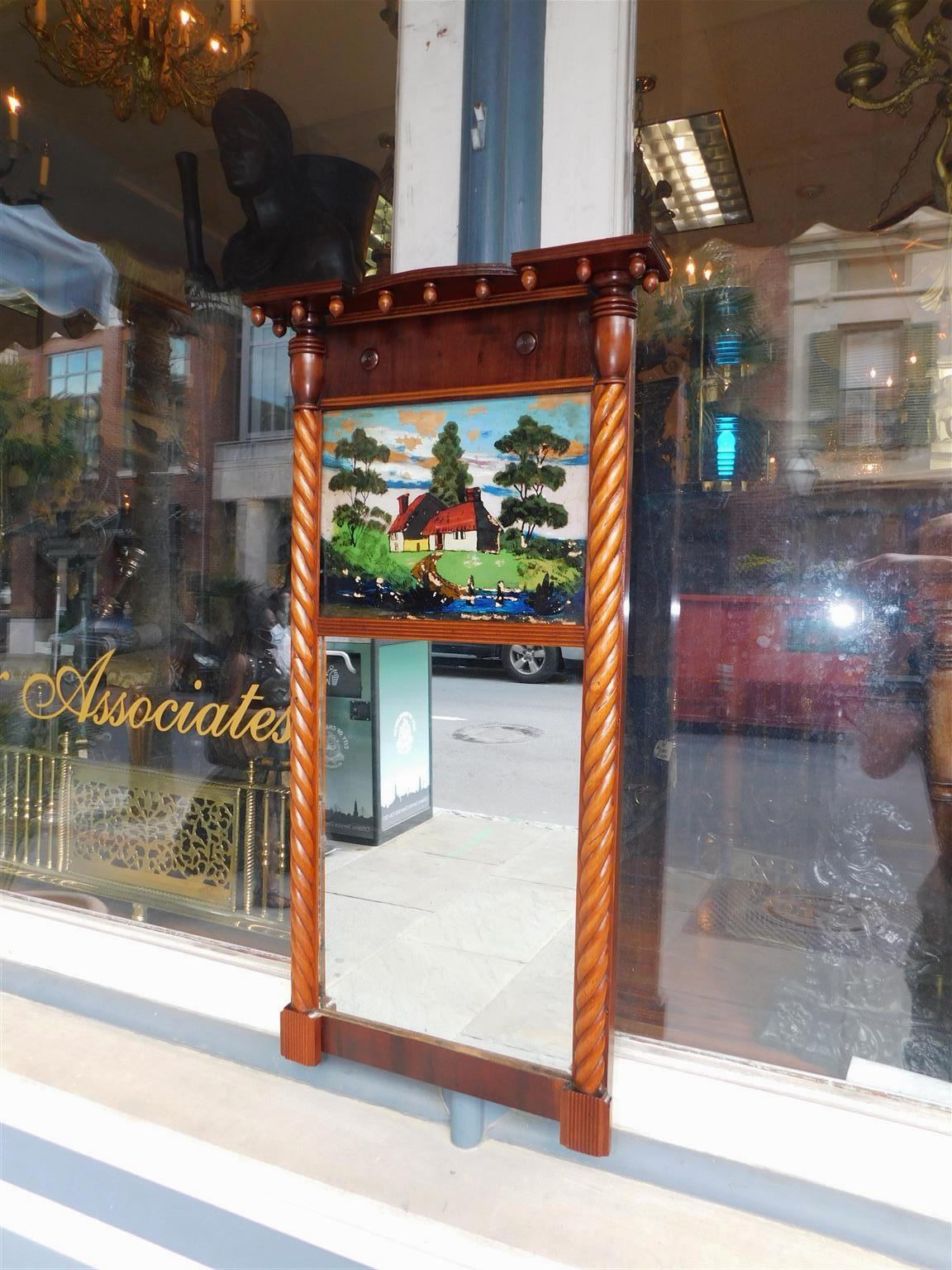 American federal mahogany églomisé wall mirror with decorative carved acorn and barley twist motif. Mirror retains the original looking glass and wood backing, Early 19th century.