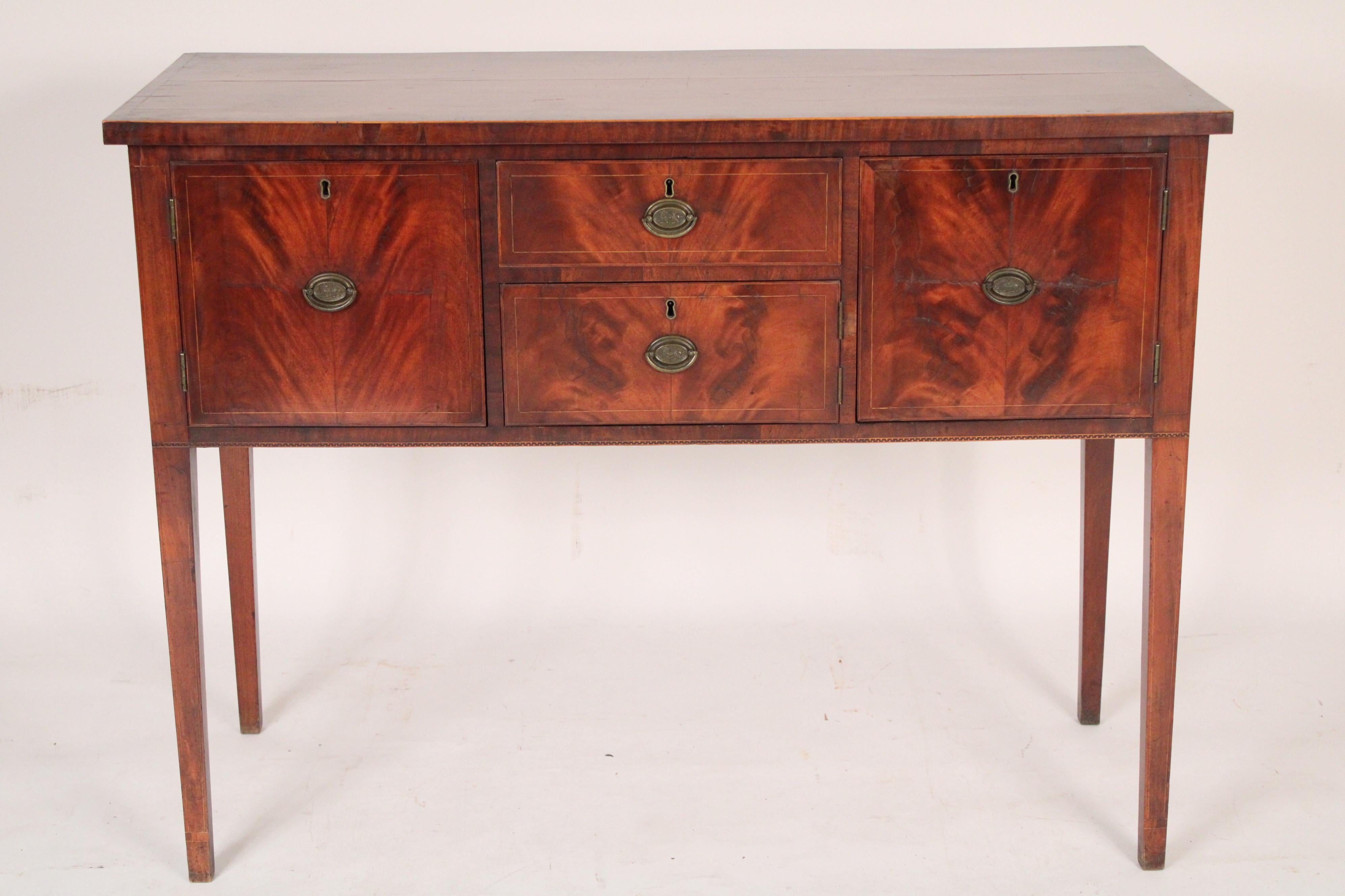 American Federal mahogany sideboard, circa 1810. With a string inlaid slightly over hanging rectangular top, two flame mahogany outer doors flanking two flame mahogany drawers resting on square tapered legs. Interesting brass hardware with lions in