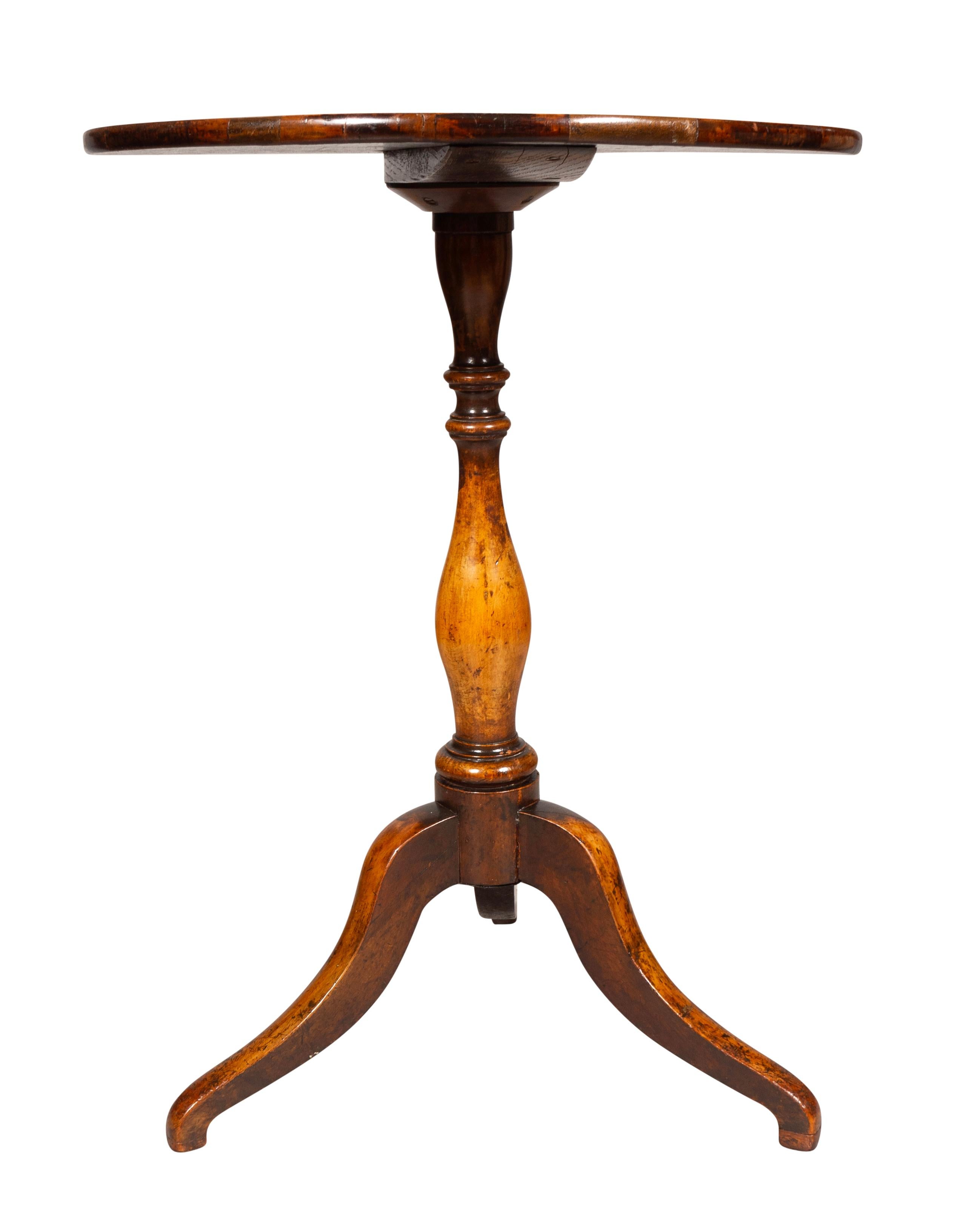 Circular fixed top with umbrella shaped inlay of exotic woods. Turned support with tripod splayed legs.