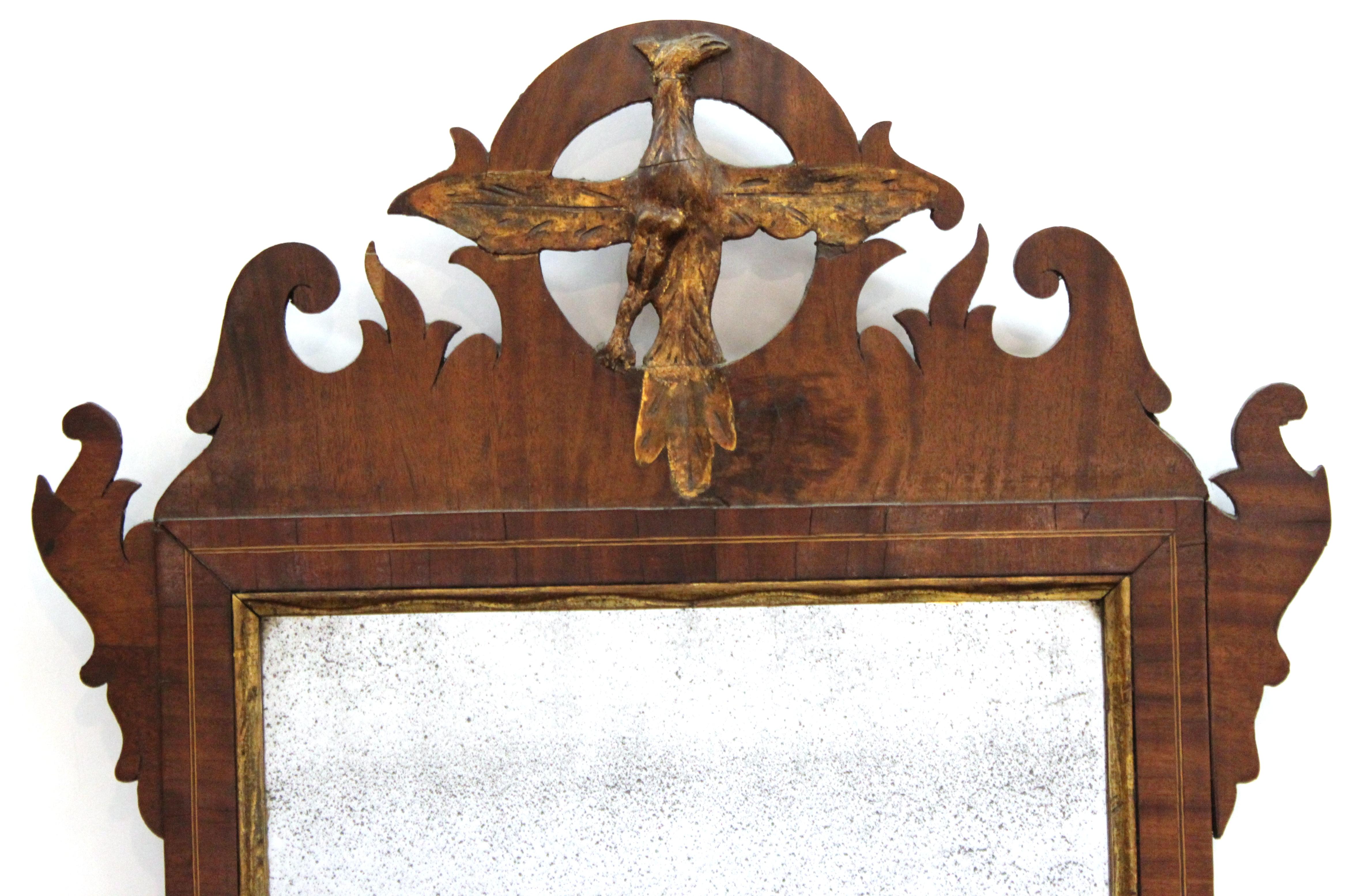 American Federal maple wood wall mirror with a pierced top and a gilt eagle motif. Borders with rails, scroll-work and foliate ears. The piece is in great vintage condition with age-appropriate wear.