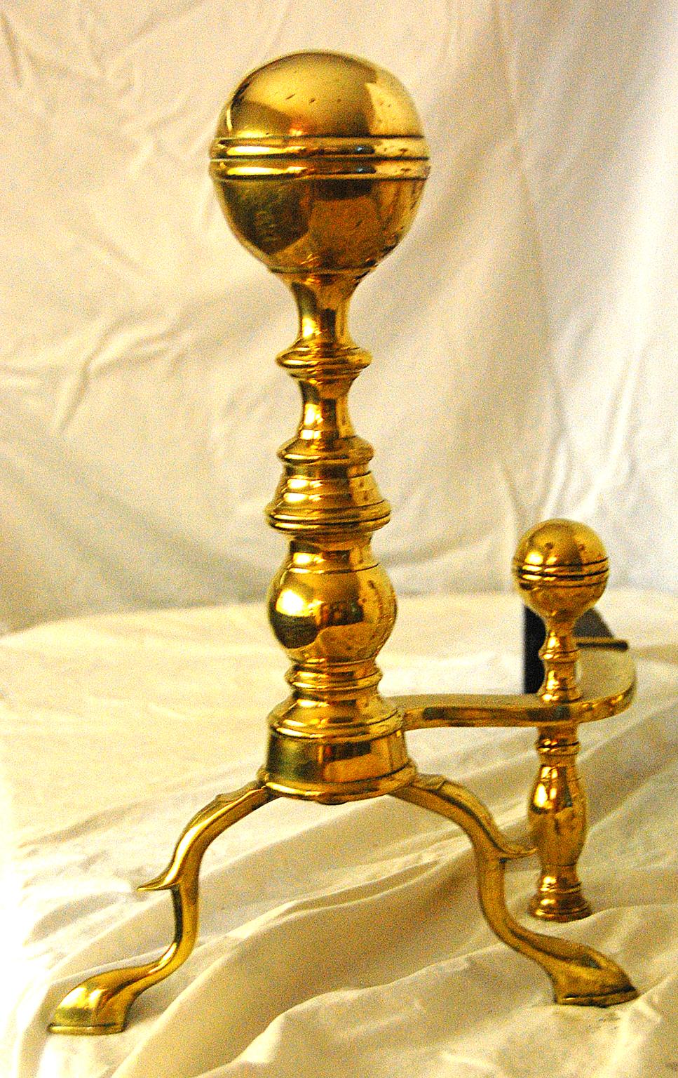 American Federal period brass ball top seamed andirons with spurred legs and spade feet, belted ball tops, Boston Region, circa 1790-1810. Wonderful original ball top and separate leg for the log stops.