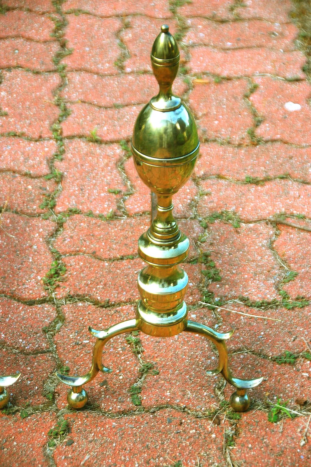 American Federal period cast brass double lemon top andirons. These substantial andirons have belting to both levels of lemons, are seamed, stand on turned bold columns with spurred legs, supported by ball feet. The wrought iron stepped log holders