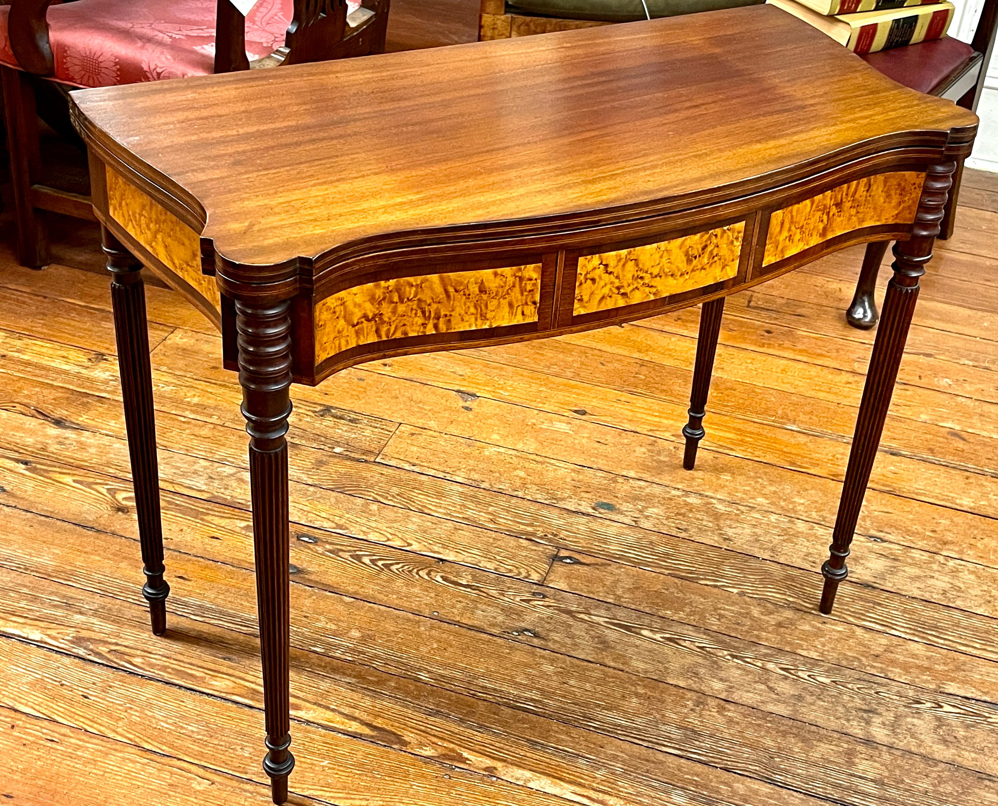 Exceptional quality antique American Federal period inlaid mahogany serpentine shaped Sheraton style gate-leg, flap-top games table. 
This table is in the manner of John and Thomas Seymour of Boston exhibiting
exceptional inlays, such as the satin