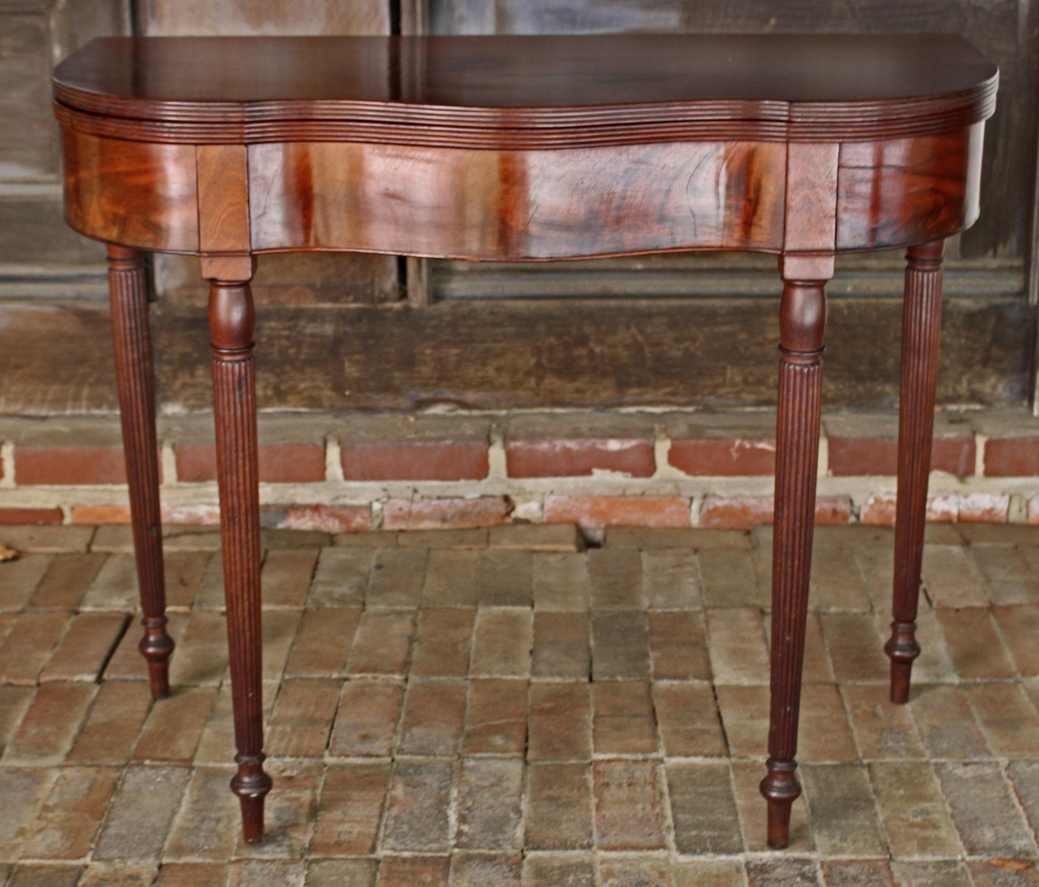 A serpentine form tea table, American, Federal period, early 19th century, New York or New England. Well figured mahogany, particularly on the serpentine fronts. Raised on tapered, reeded legs with vasi-form details. Early, quality stacked block
