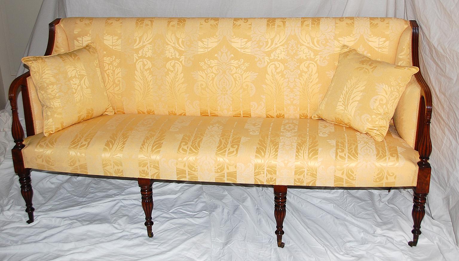 American Federal period Sheraton mahogany carved sofa. The four front legs are turned and reeded, the arms have the inverse pattern of turning and are similarly reeded. The four back legs are tapered and create a flowing line to the back. Two of the