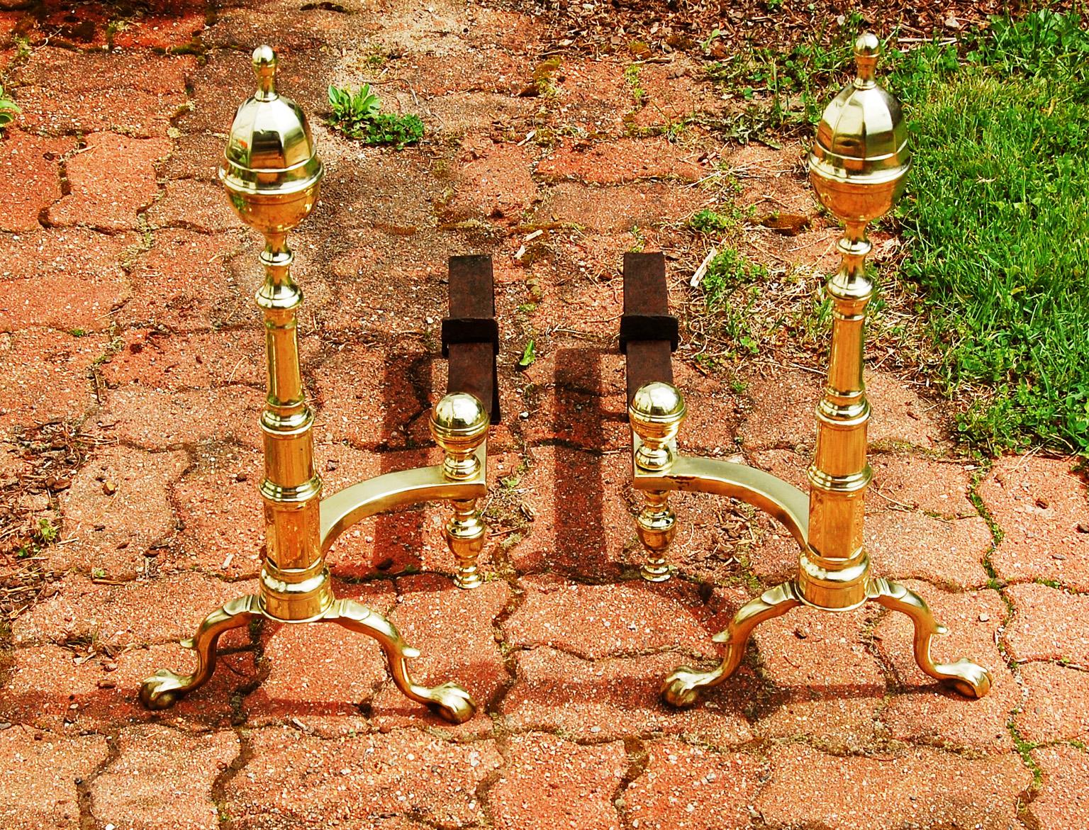 American Federal Philadelphia cast brass faceted acorn top large andirons. The motif of faceting is repeated in the stepped faceted column as well as on the acorns. The columns rest on cabriole legs with spurred knees and ball and claw feet. As one