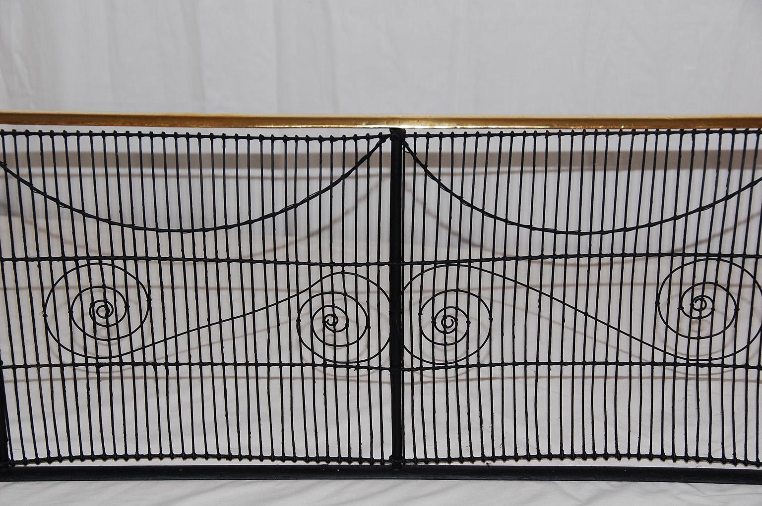 American Federal period wire and brass fireplace fender. The wire fender has an extra layer of detailing in the shape of swags and scrolls against vertical wire background. The top rail is half round brass. At 42 inches in width it fits many modern