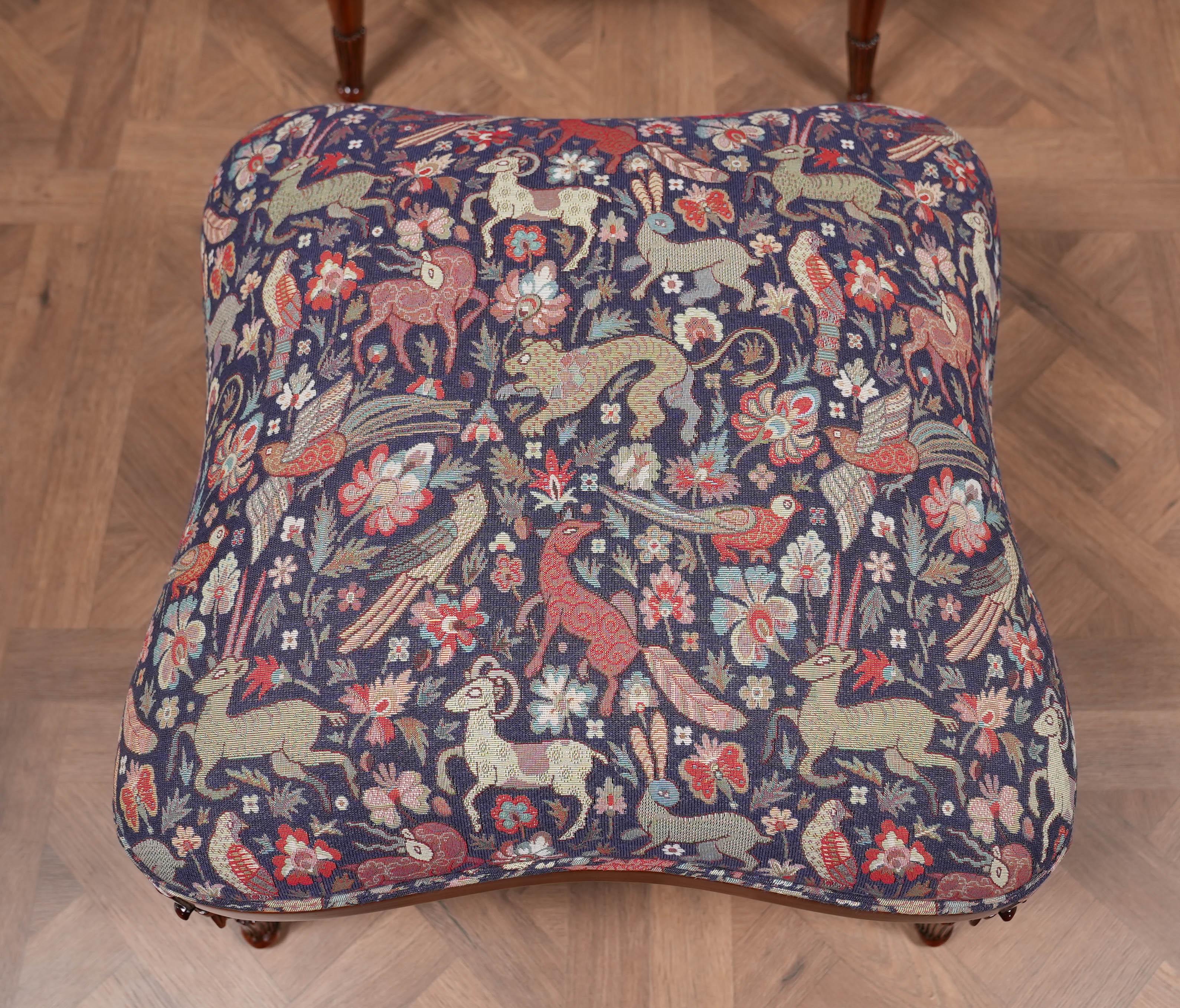An extremely popular American Fireside Chair and ottoman designed after an original antique chair and ottoman. This reproduction antique has all of the features of it’s ancestral inspiration with a solid mahogany barrel back frame, hand carved
